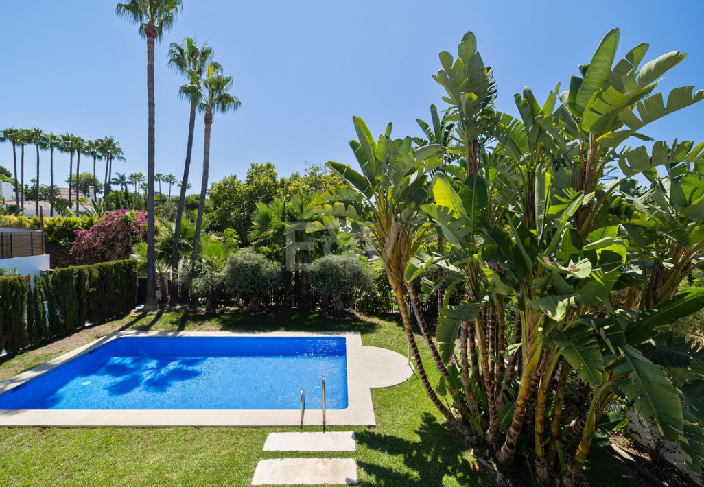 Villa elegante con piscina, jardín tropical y atractivo urbano