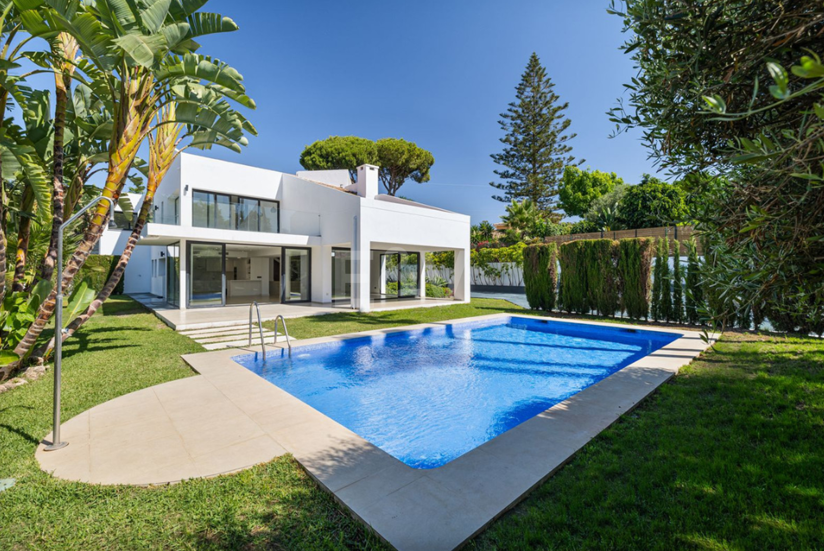 Villa elegante con piscina, jardín tropical y atractivo urbano