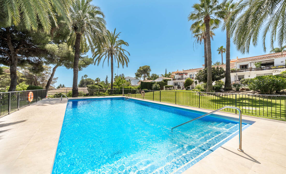 Oportunidad única: encantador y amplio apartamento de 3 dormitorios en ubicación privilegiada con vistas a un exuberante jardín tropical, piscina y un vistazo al mar