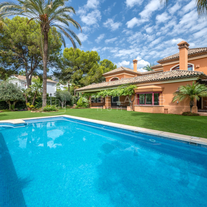 Amplia y encantadora villa de 4 dormitorios con jardín tropical en Altos Reales, Milla de Oro de Marbella.