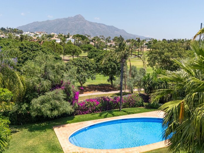 Elegante villa pareada en primera línea de golf en Nueva Andalucía con jardín privado y vistas a La Concha