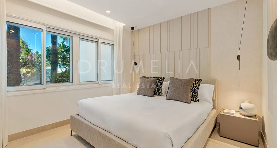 Apartamento de lujo en primera línea de playa en Bahía del Velerín con vistas al mar, terraza y acabados de diseño.