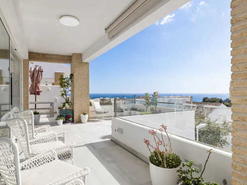 Villa de 3 dormitorios en Benalmádena con vistas al mar, 100 m² de terrazas, jardín privado y piscina comunitaria.