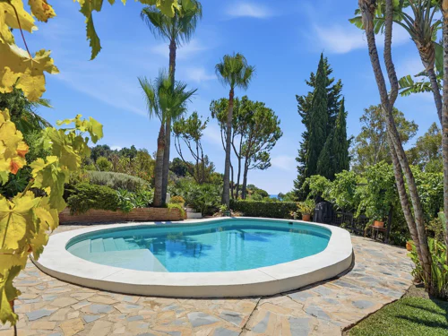Villa en Benalmádena con vistas al mar, piscina privada, jardín, garaje y apartamento de invitados.