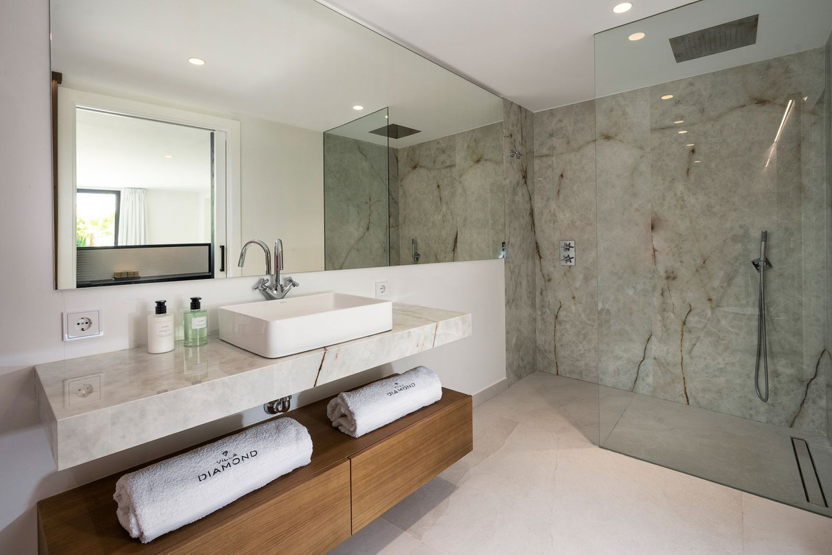 Bathroom with a floating vanity, square sink, large mirror, and a glass-enclosed walk-in shower.