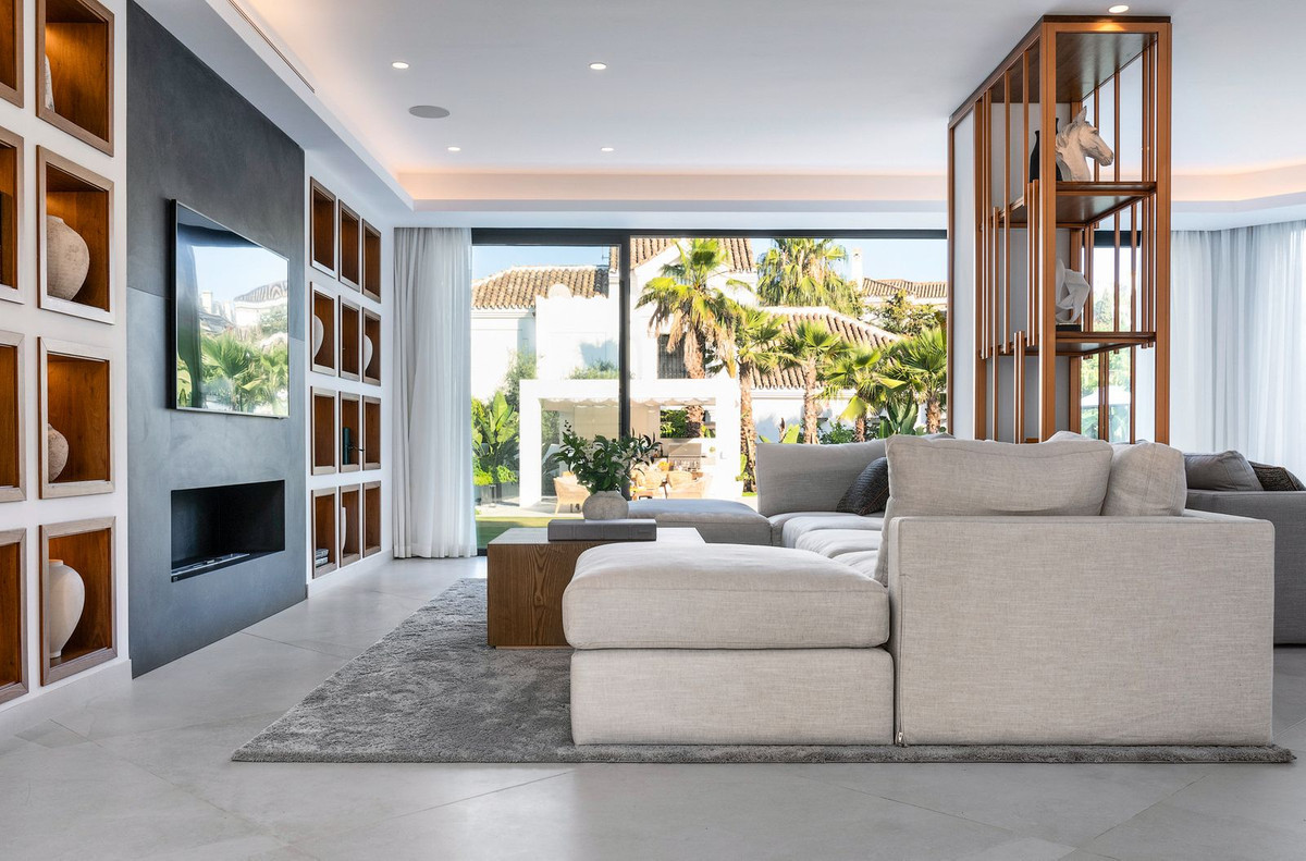 Living room with a sectional sofa, television on a dark wall, and large sliding doors to a patio.