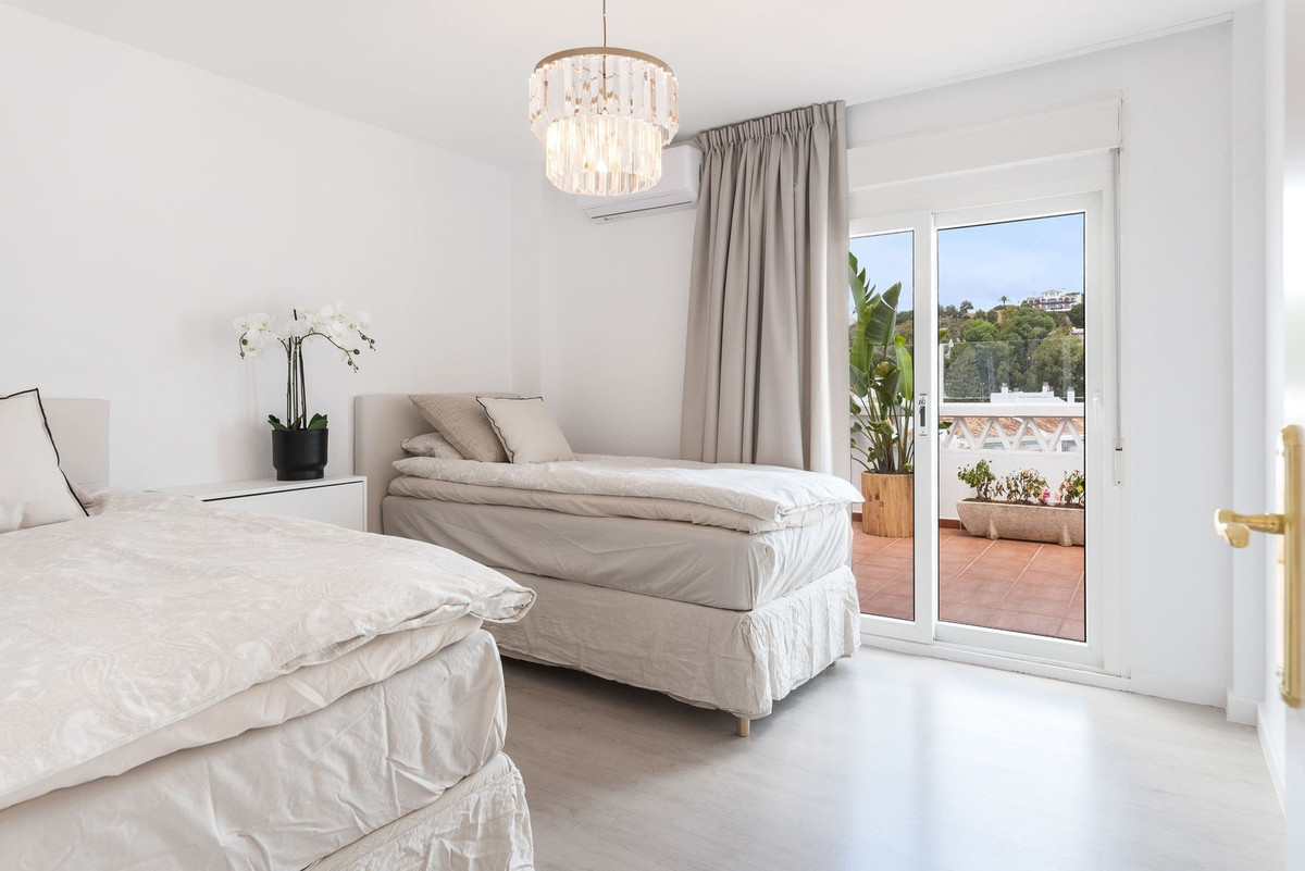 Bedroom with two twin beds, a chandelier, and sliding glass doors leading to an outdoor patio.