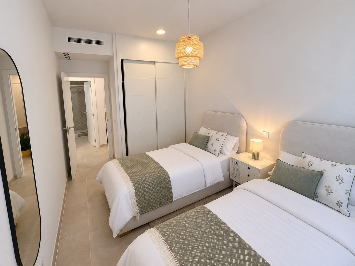 Bedroom with two single beds, bedside table with lamp, built-in wardrobe, and a visible doorway.