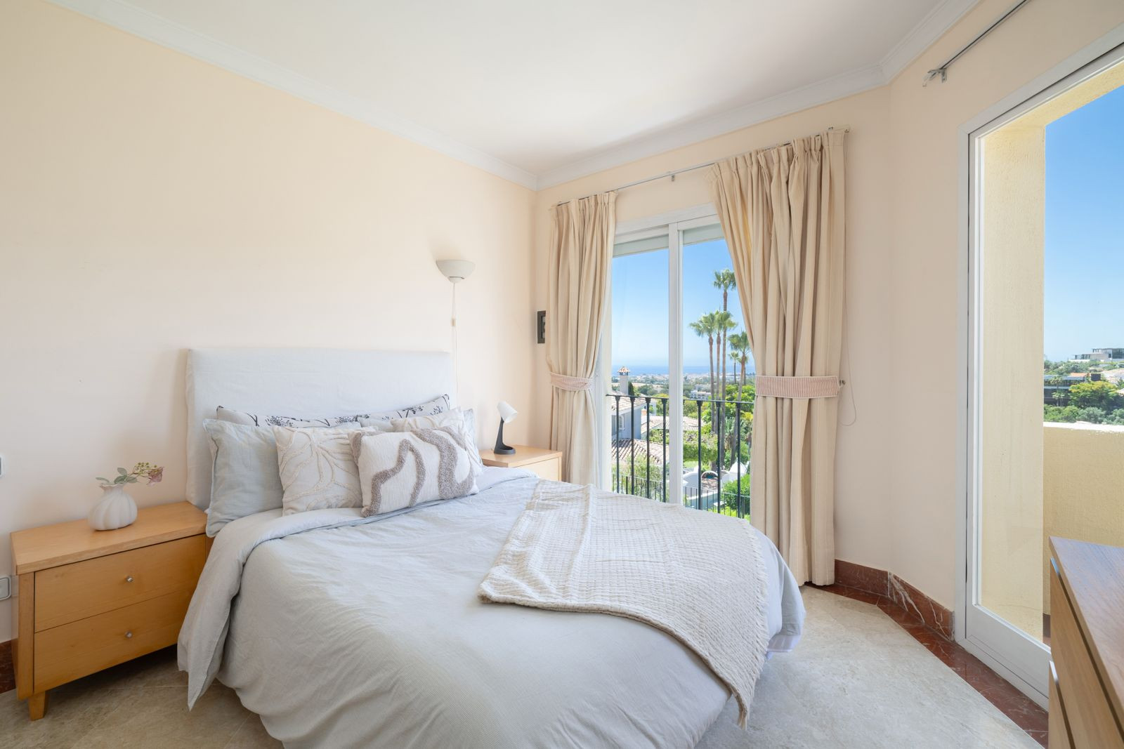 Inviting bedroom with a balcony door revealing a scenic view and inviting decor elements.