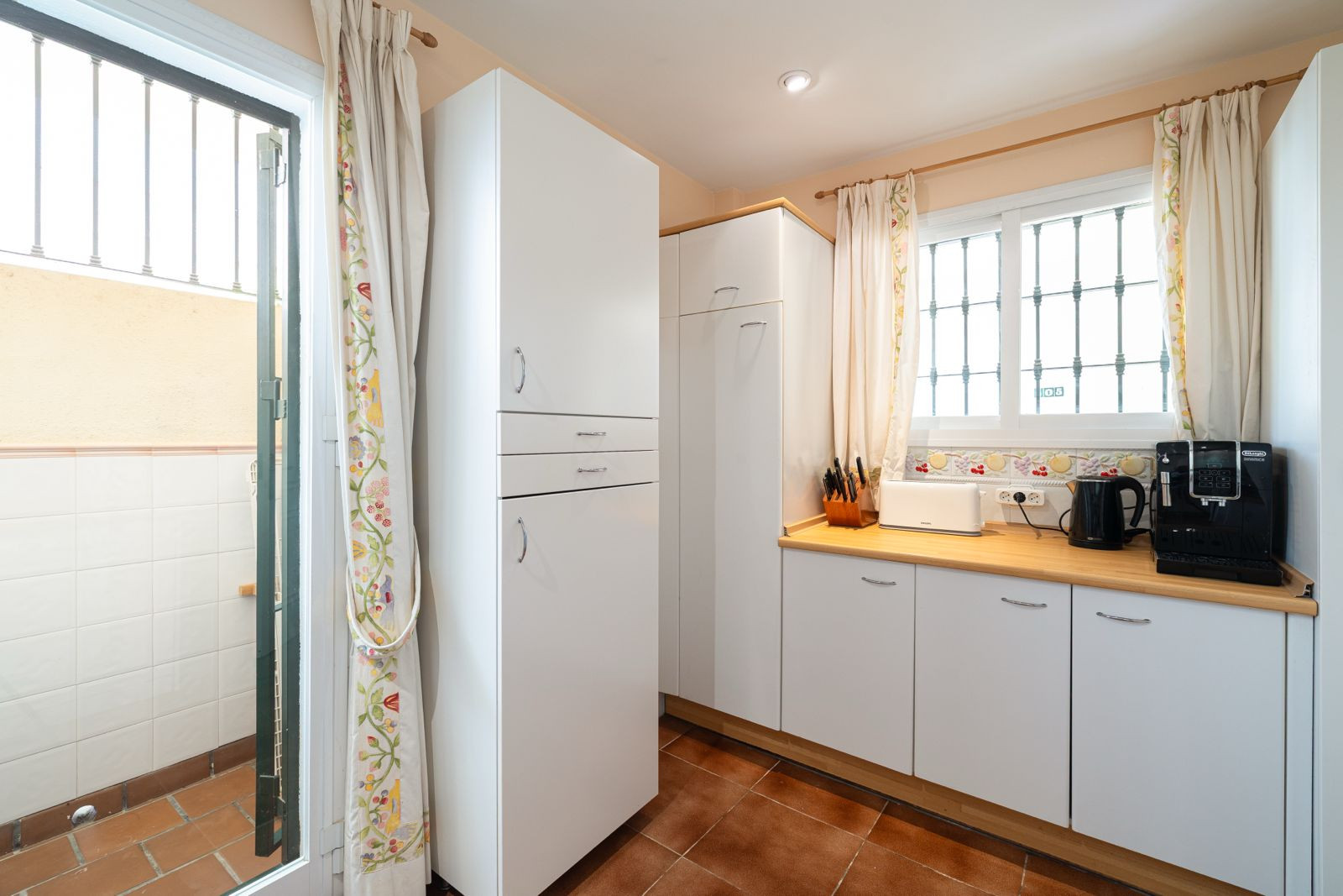 View into the kitchen corner, showcasing cabinetry and a doorway leading to an outdoor space.