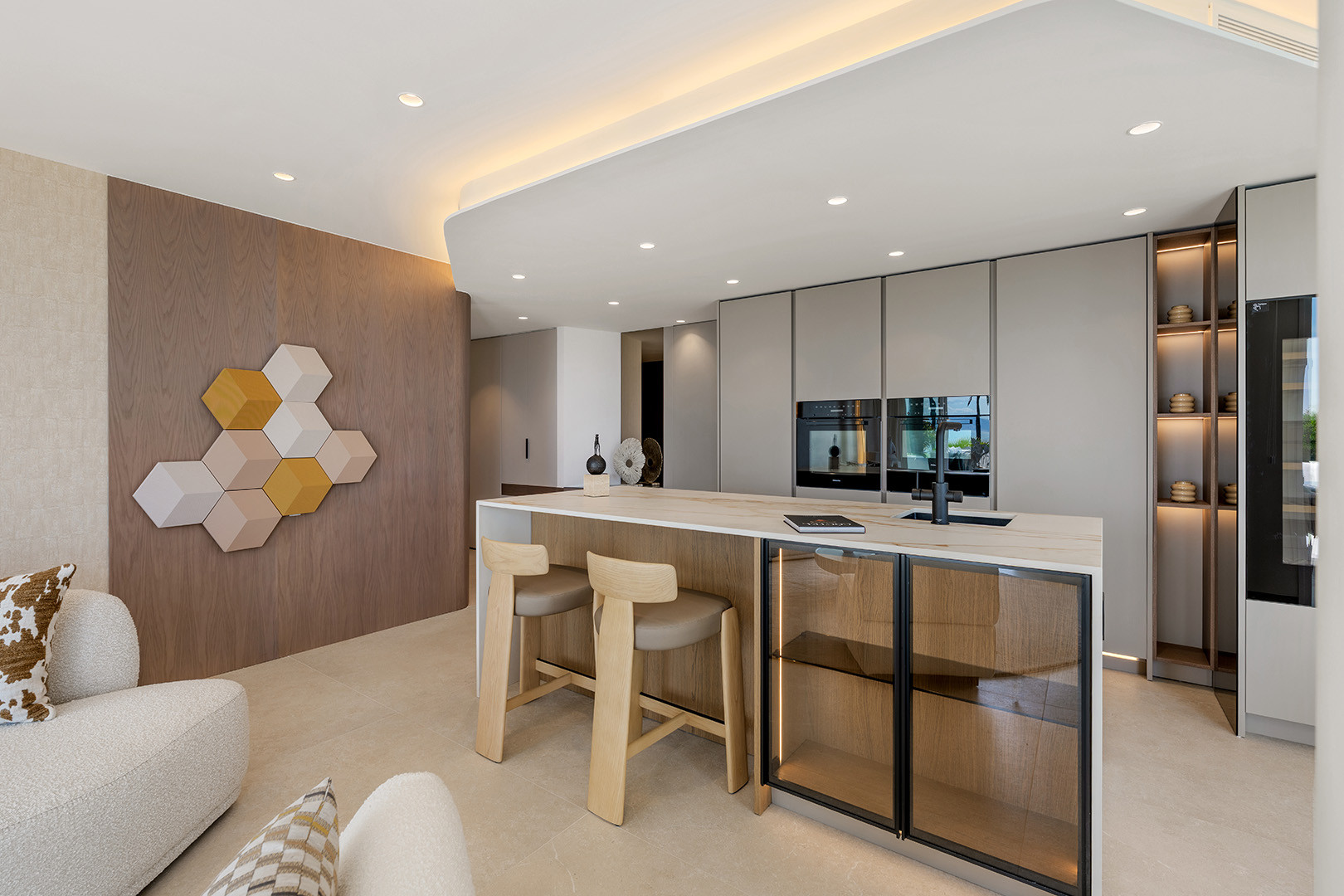 Modern kitchen with wood paneling, built-in appliances, a large island, and bar stools.