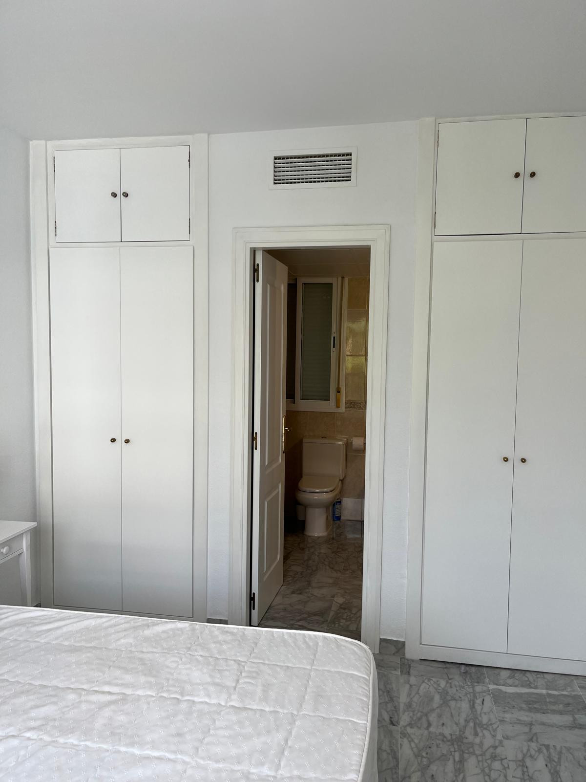 Entryway with closets and bathroom access visible in background.