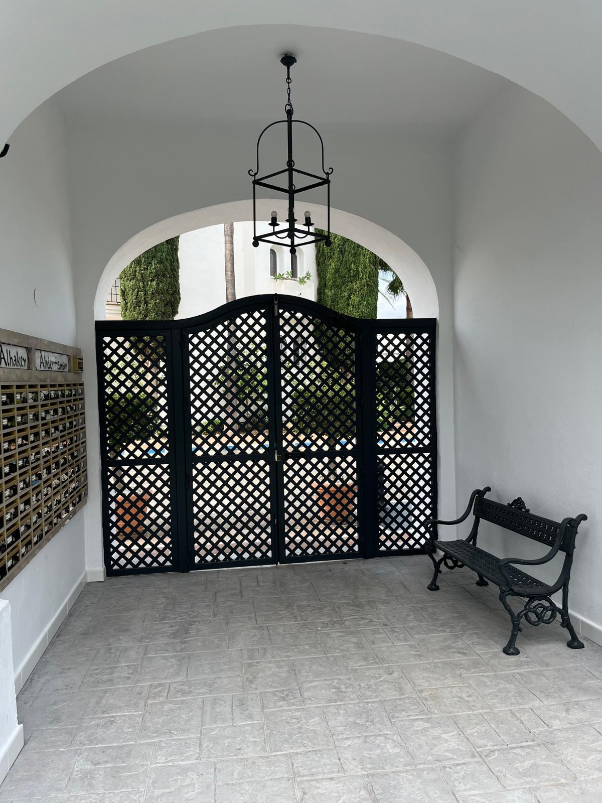 Entrance hall with black double gates and decorative lantern.