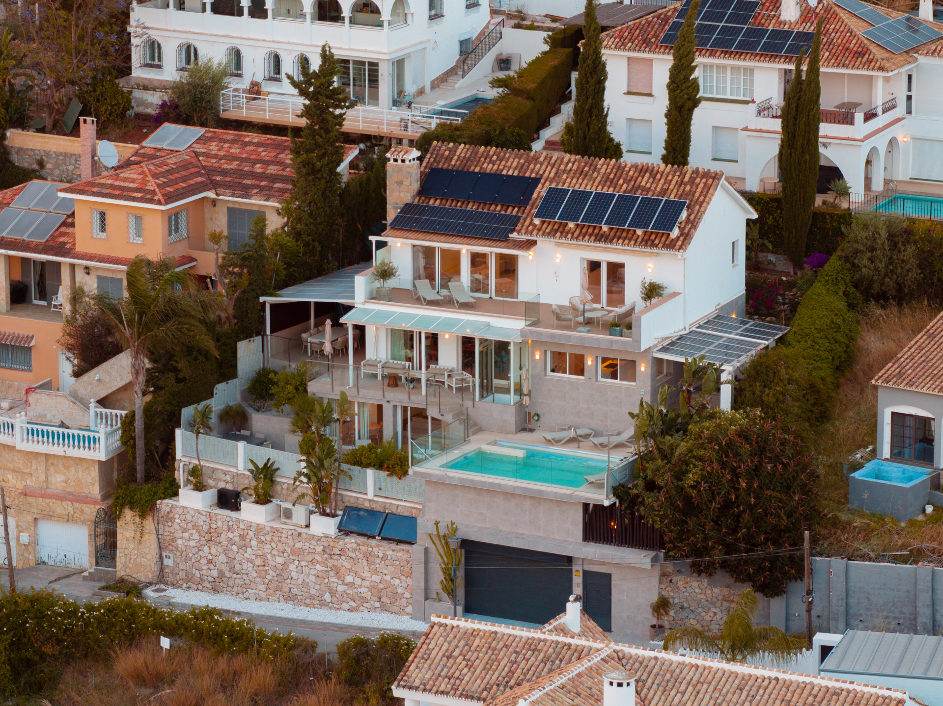 Aerial view of the villa showcasing a pool and solar panels on the roof.