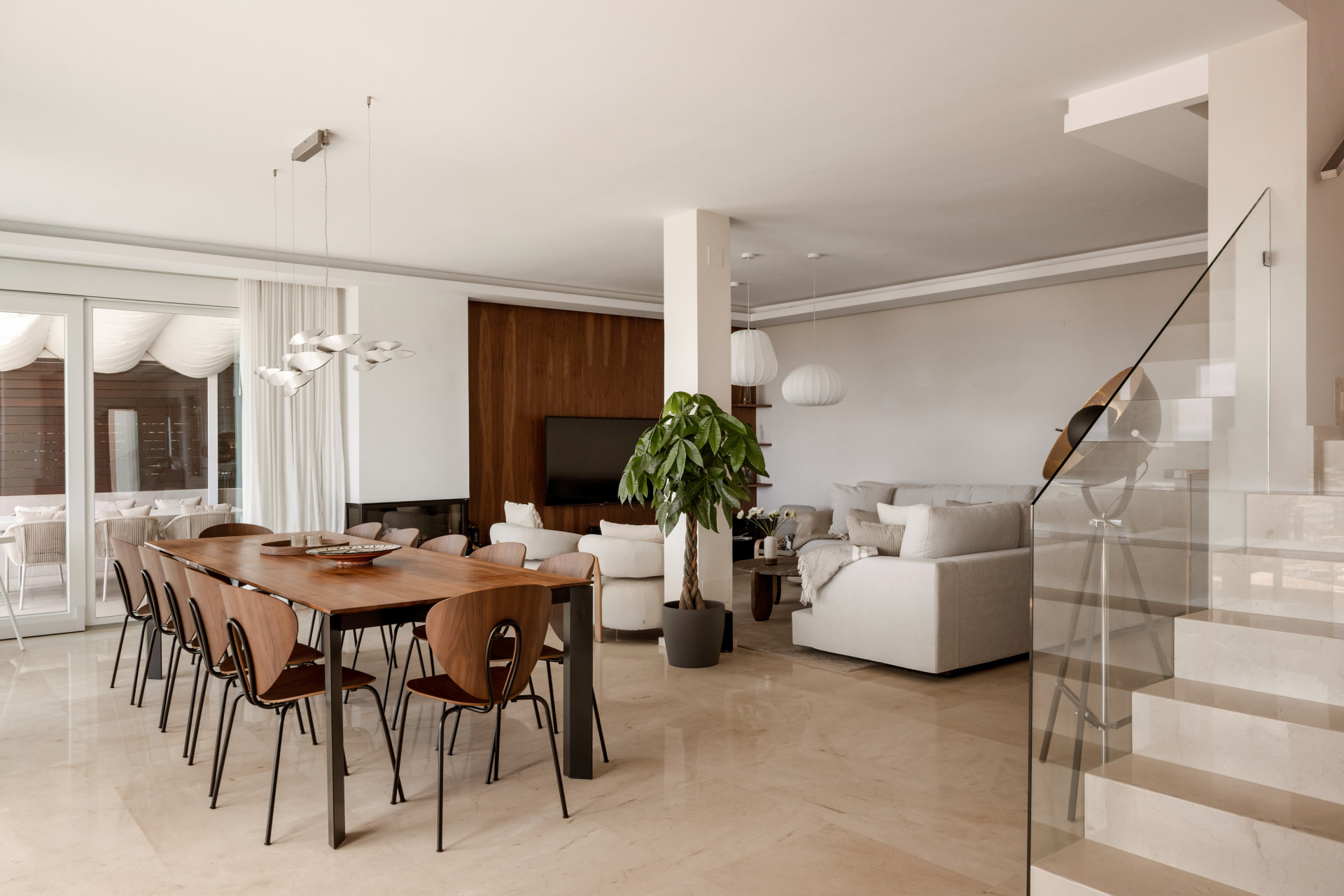 Open plan living and dining area featuring a long wooden table and modern furniture.