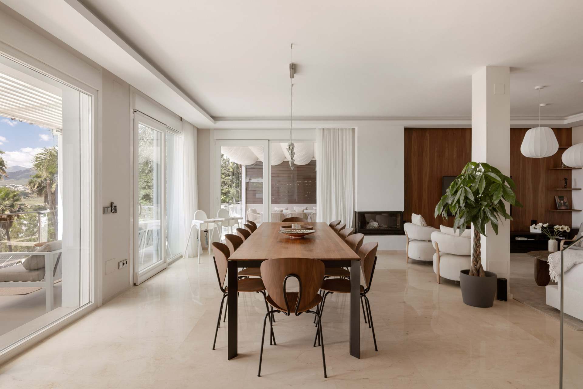 Dining area with large windows exposing outdoor views and sleek decor.