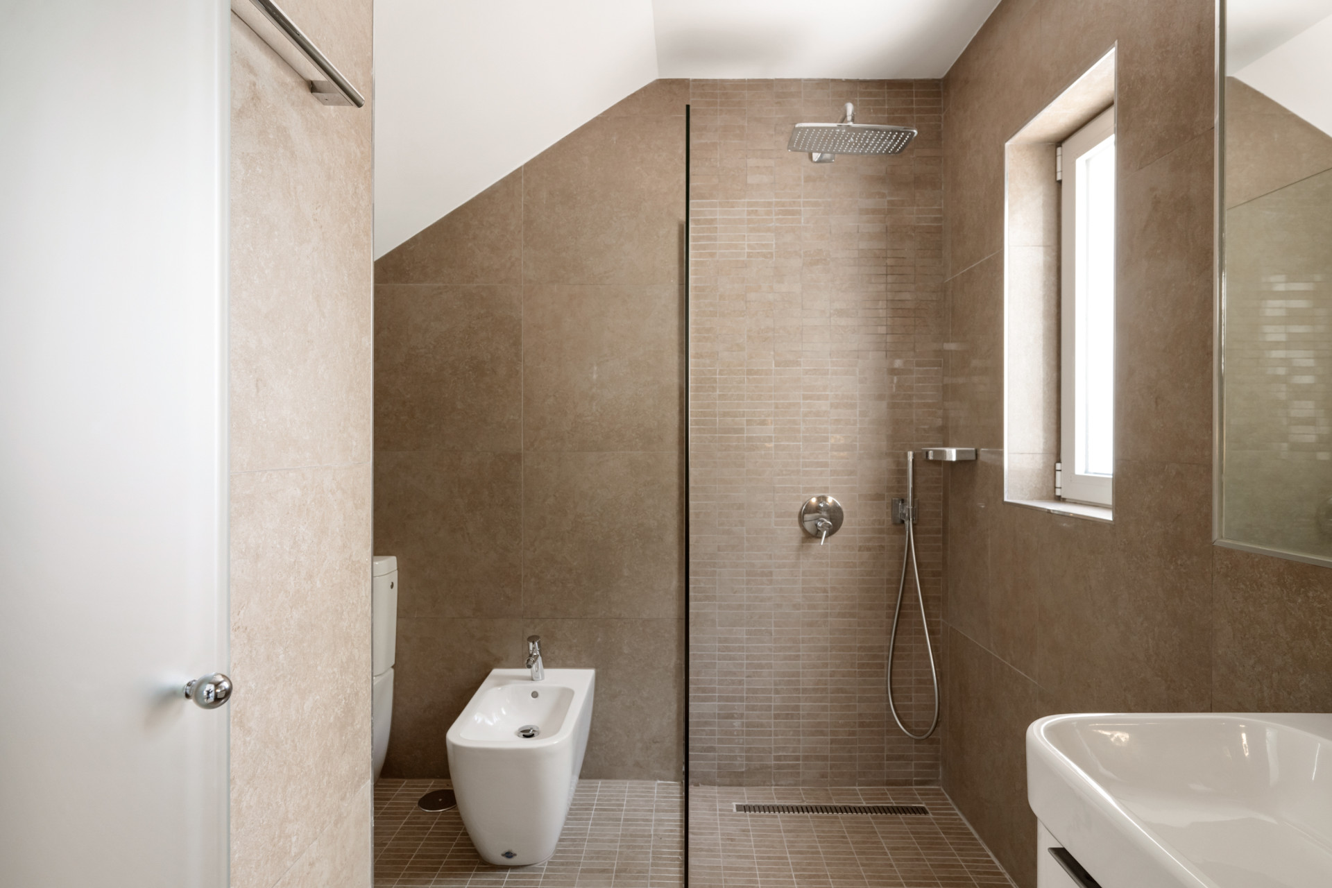 Modern bathroom with a walk-in shower and neutral tile design.