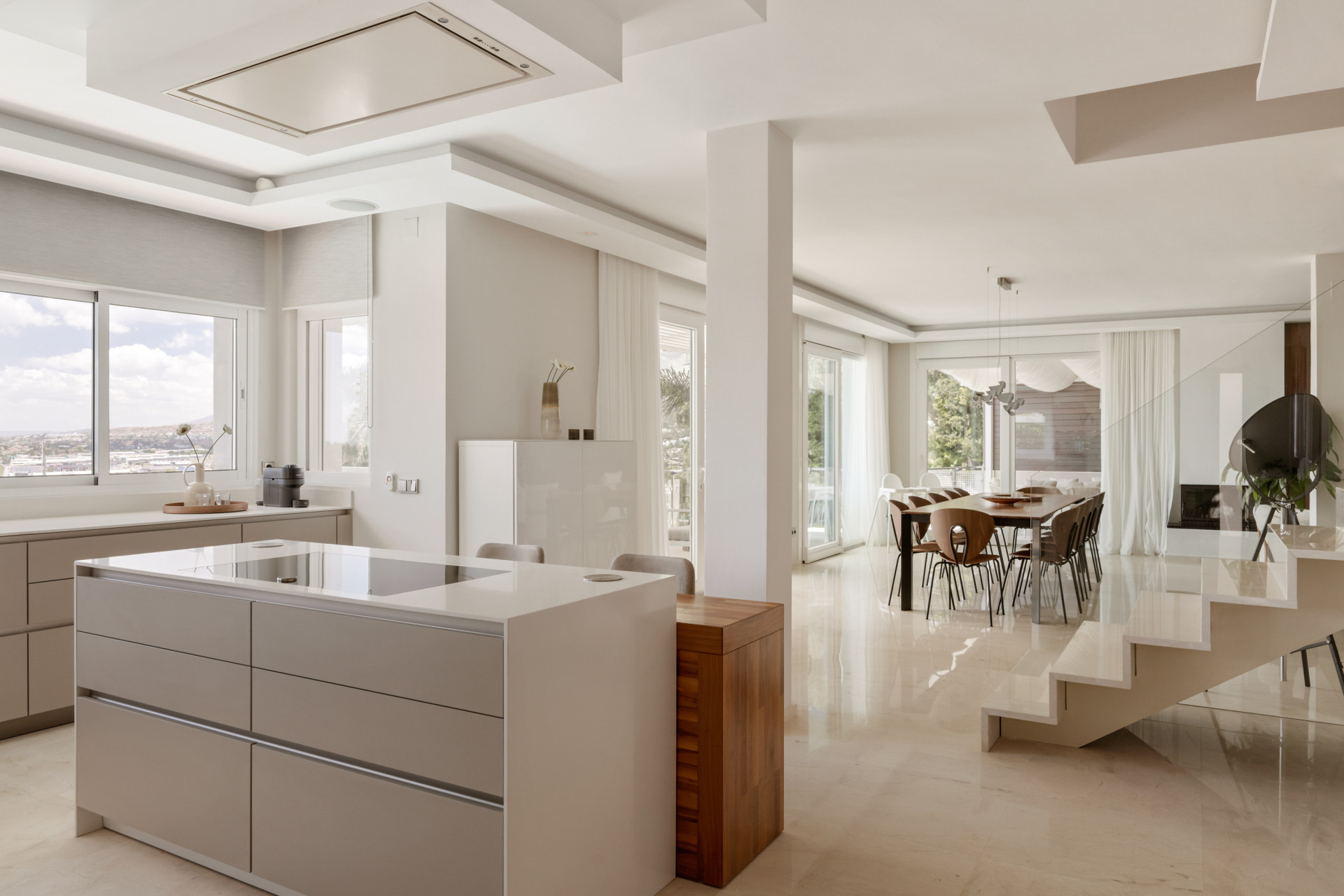Contemporary kitchen with an island and integrated appliances providing ample light.