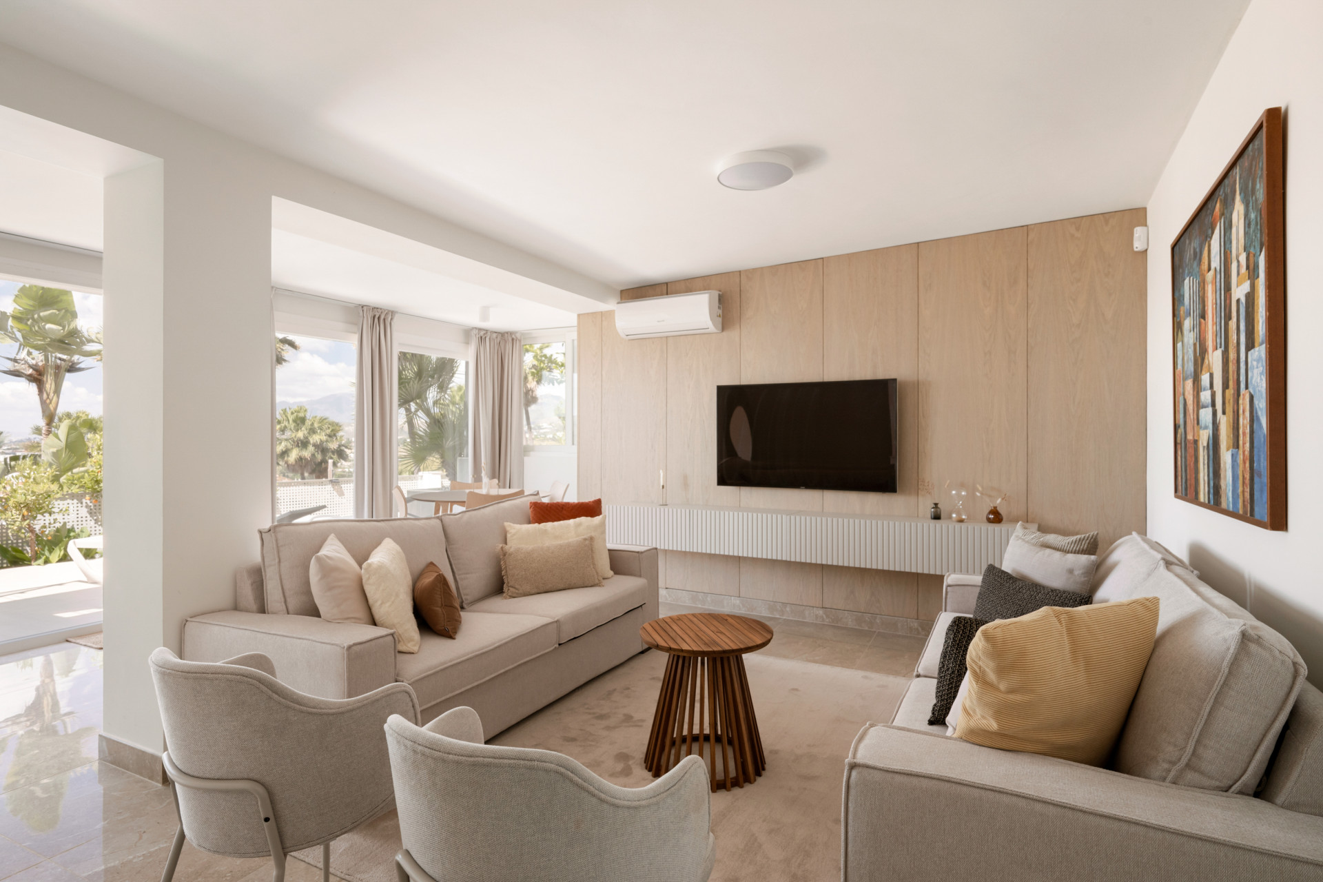 Living room with sofas, a coffee table, and a mounted TV on a wooden wall.