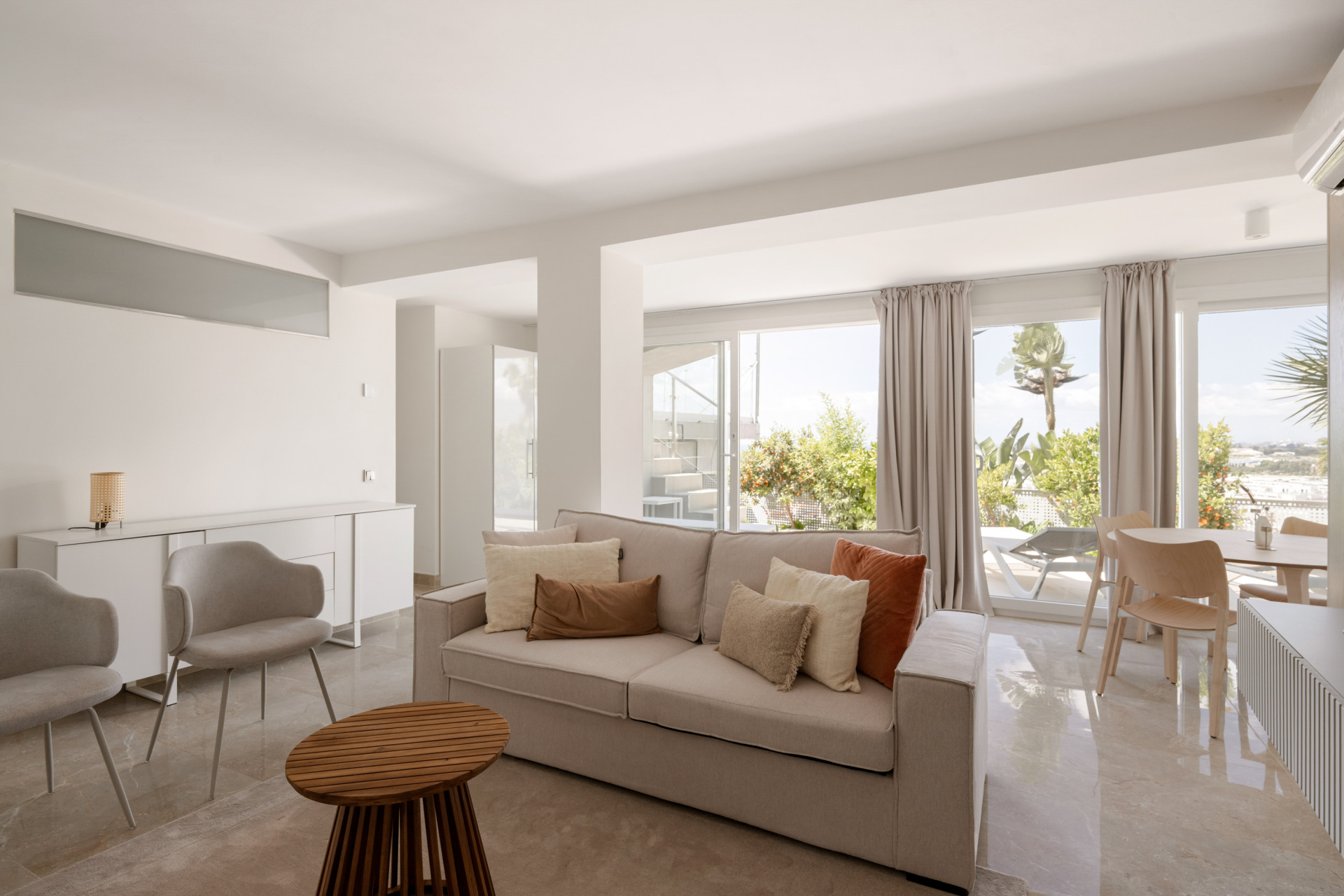 Spacious living area with large windows and modern furniture.
