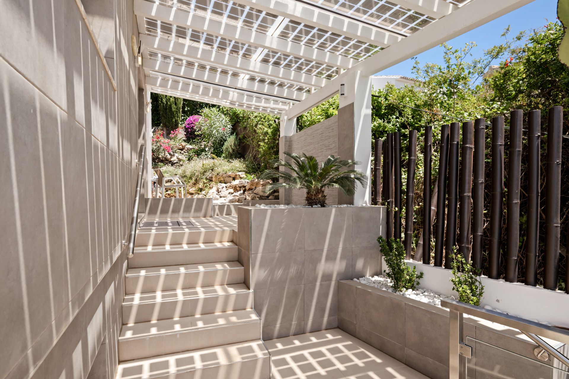 Staircase leading to a garden with shade and flowers.