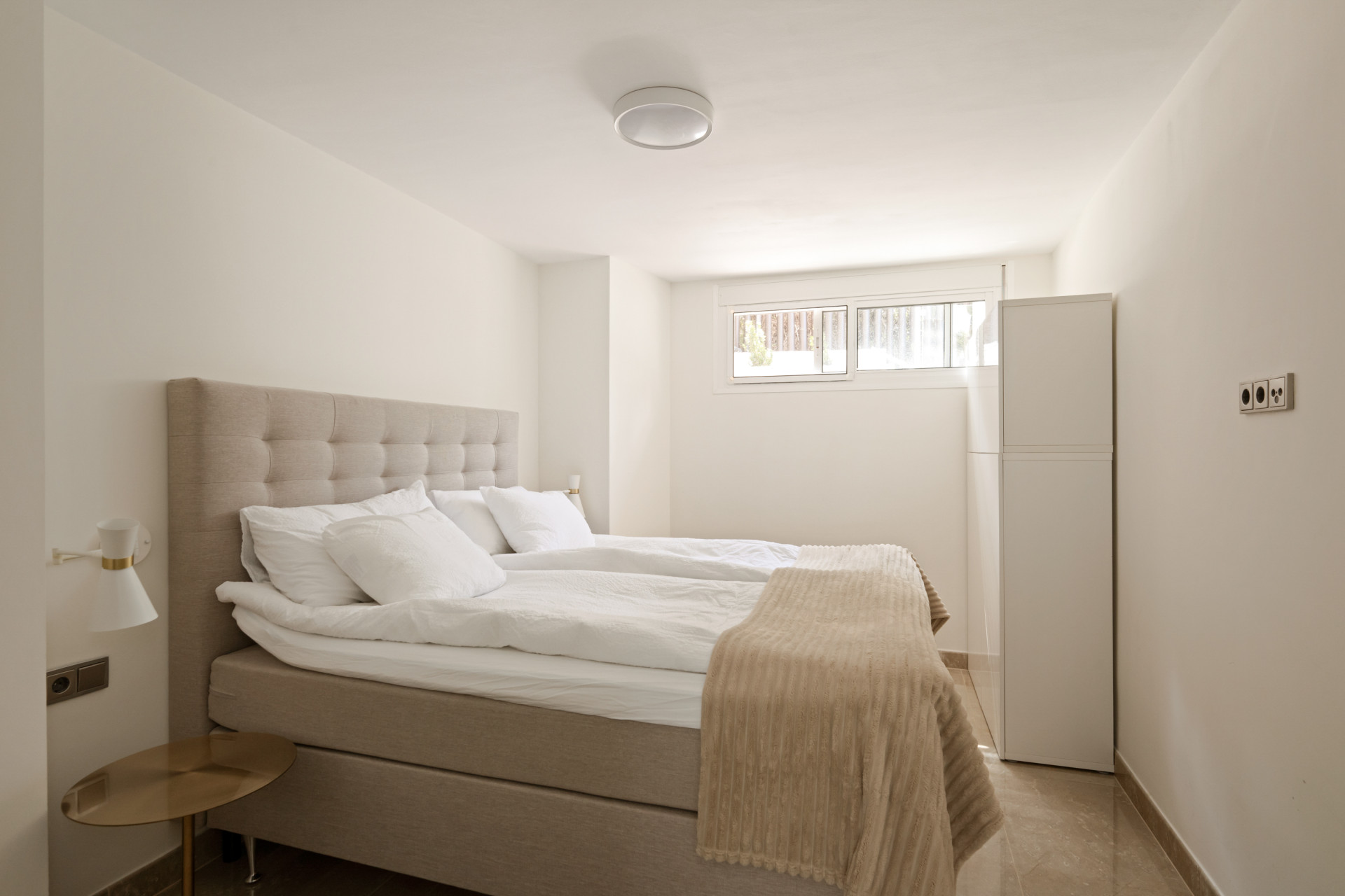 Cozy bedroom with a bed, bedside table, and storage cabinet.