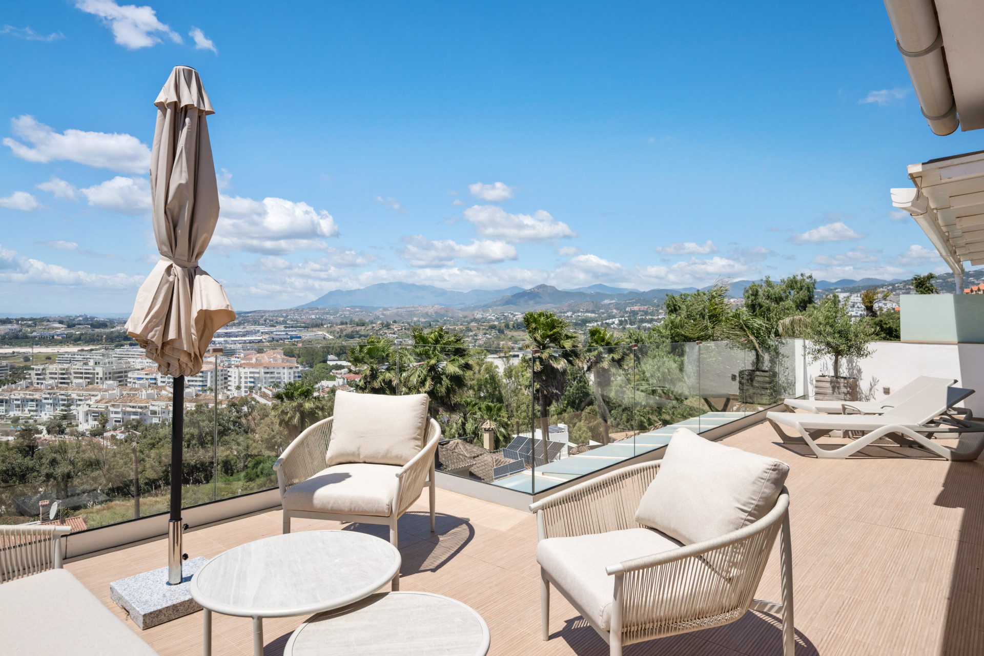 Lounge area featuring seating, patio umbrella, and mountain views.