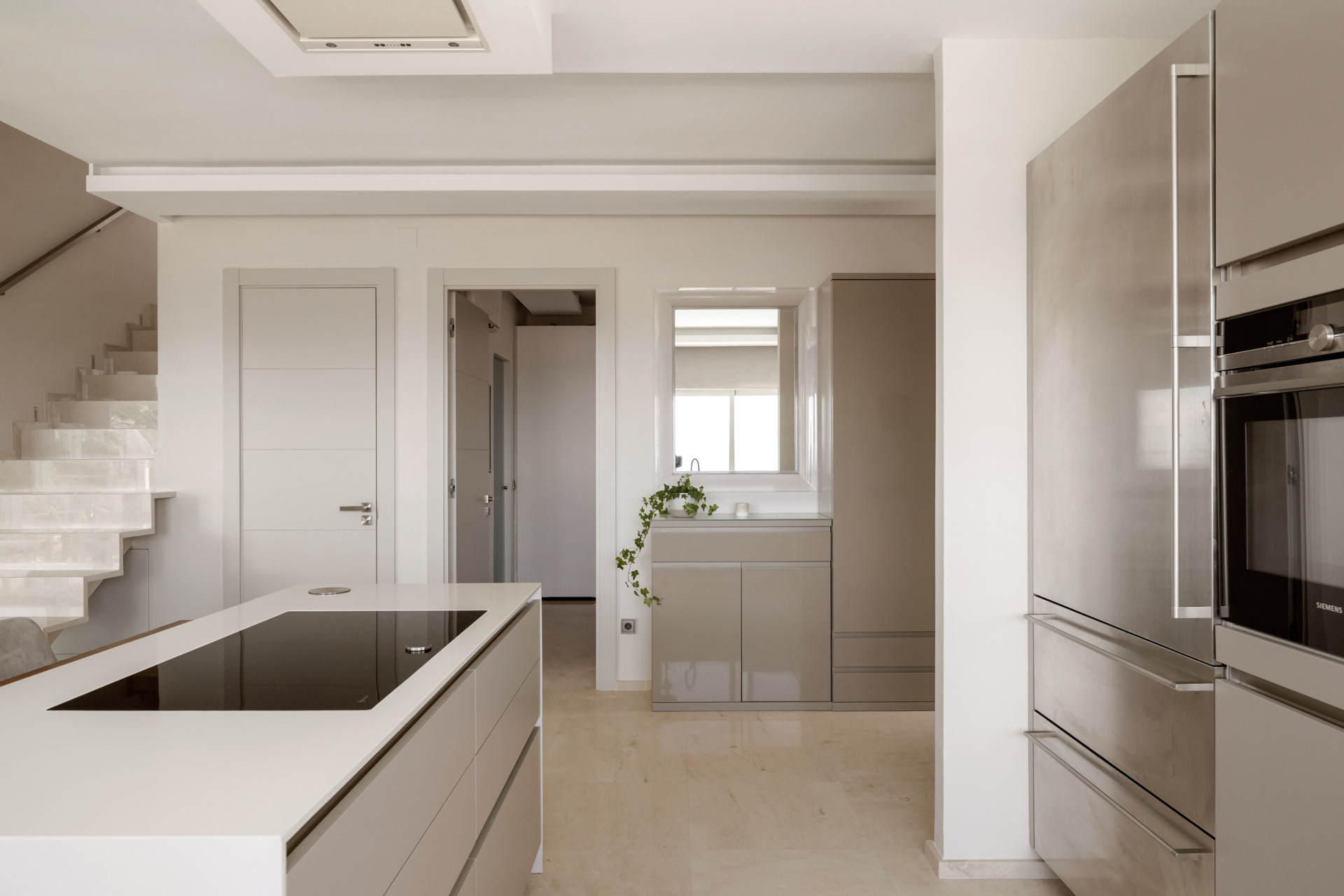 Modern kitchen with gray cabinetry, an island, and white countertops.