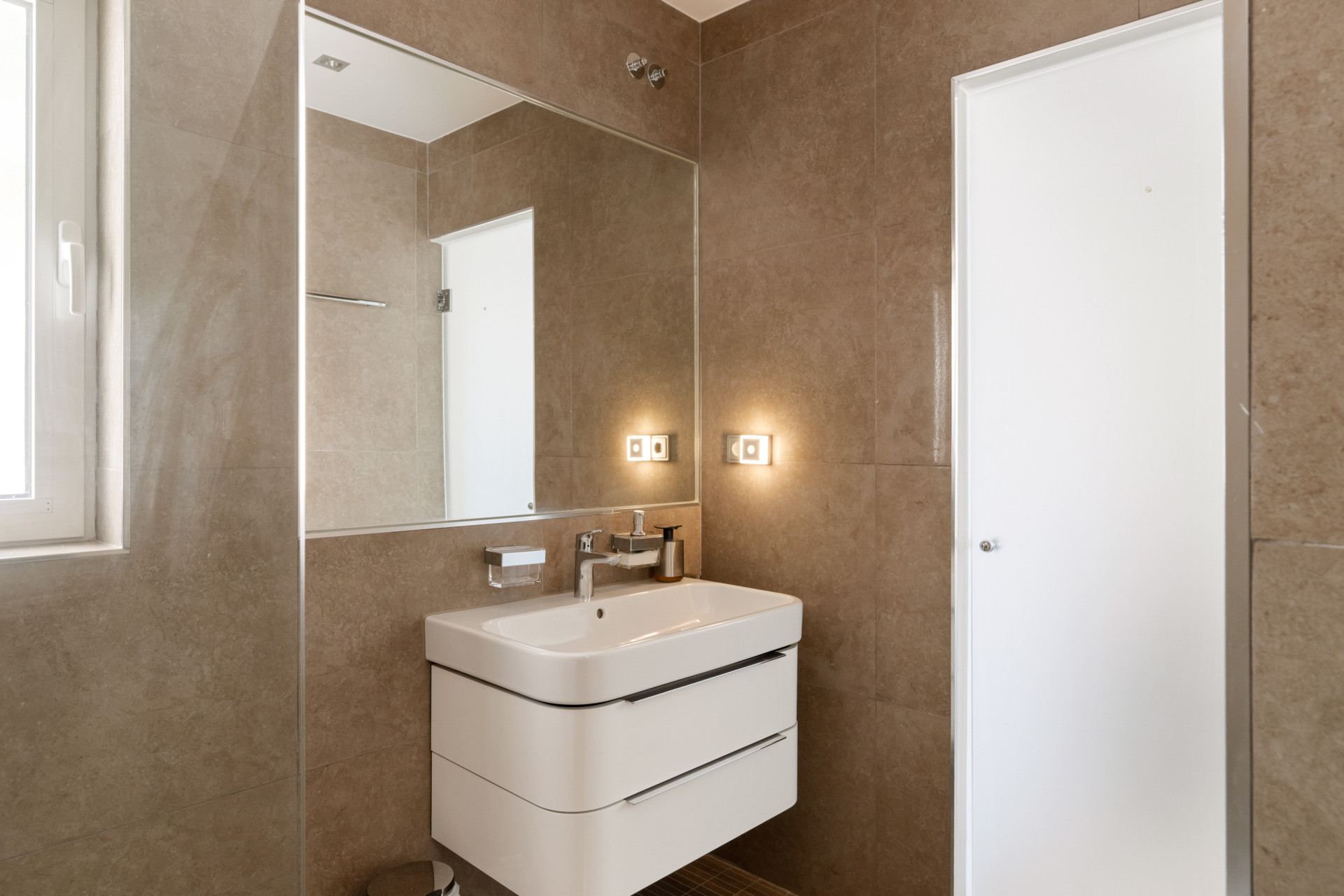 Vanity area with sink and mirror in a contemporary bathroom setting.