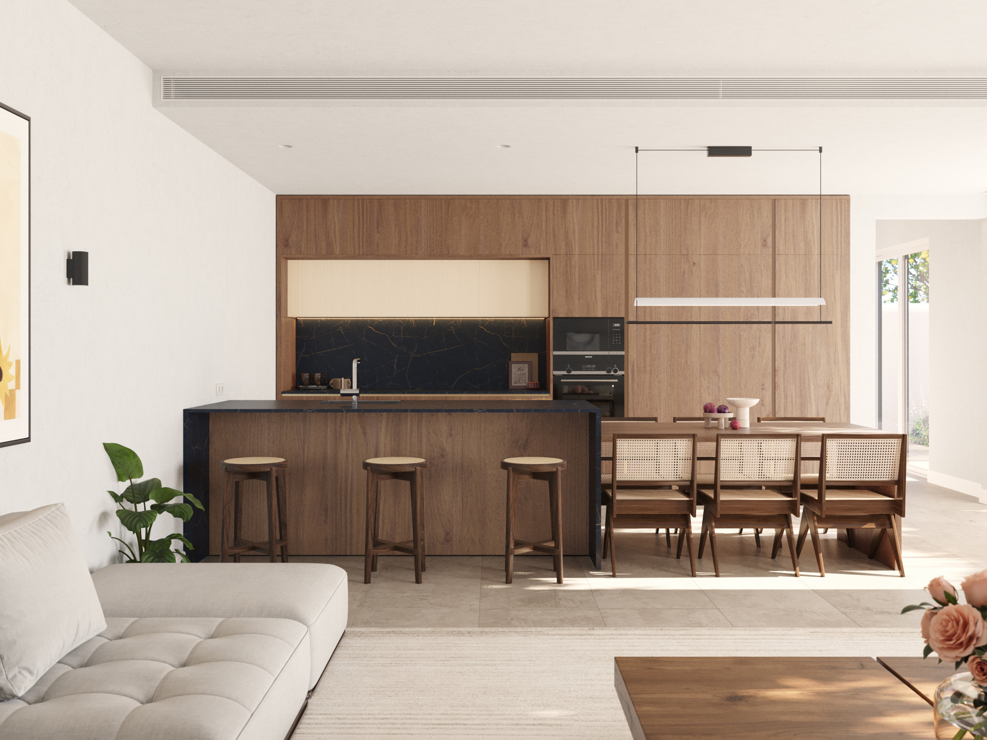 Open plan living space with a kitchen island, dining table, and partial view of a light-colored sofa.
