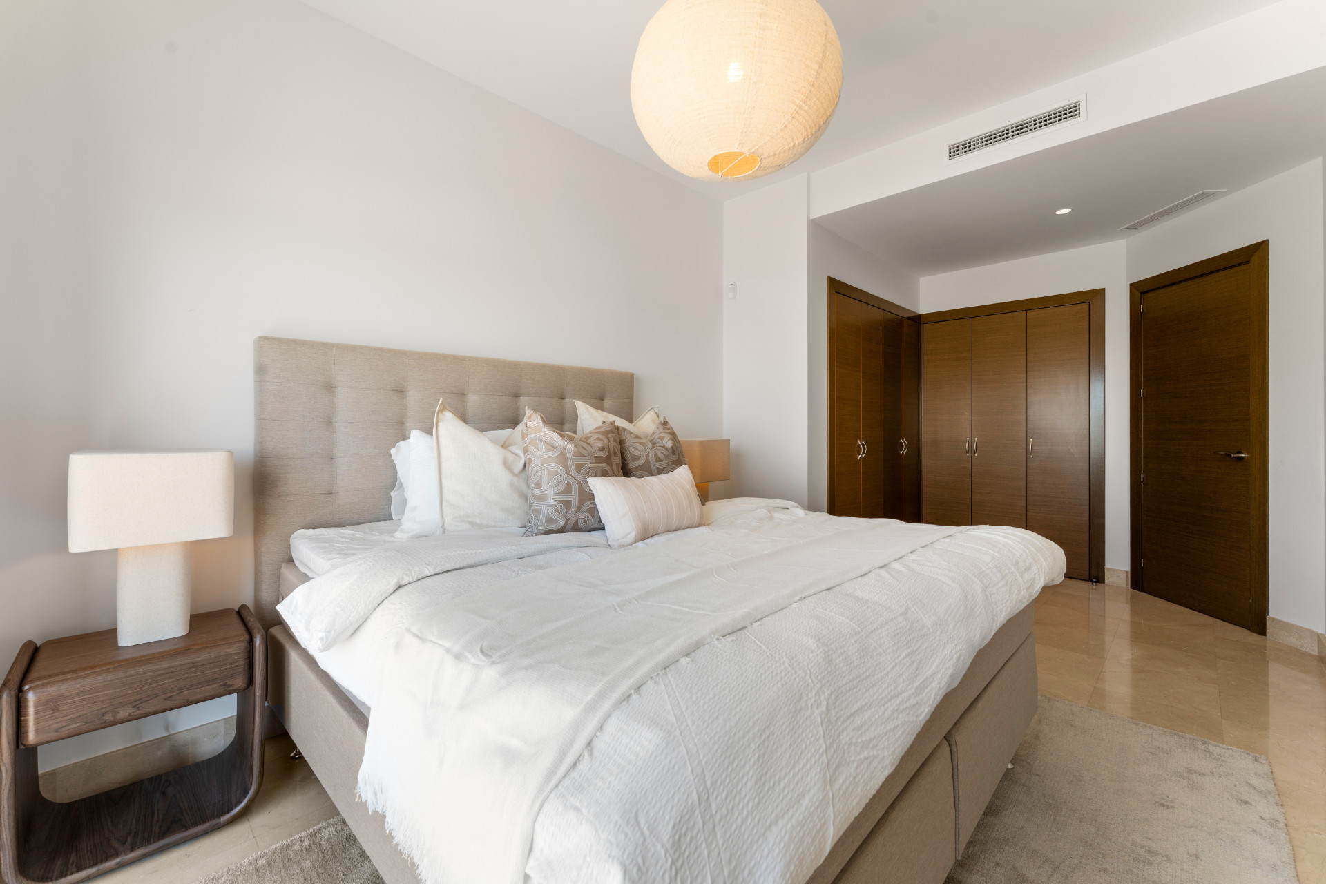 Another bedroom with a bed, stylish lamp, and built-in wardrobe.
