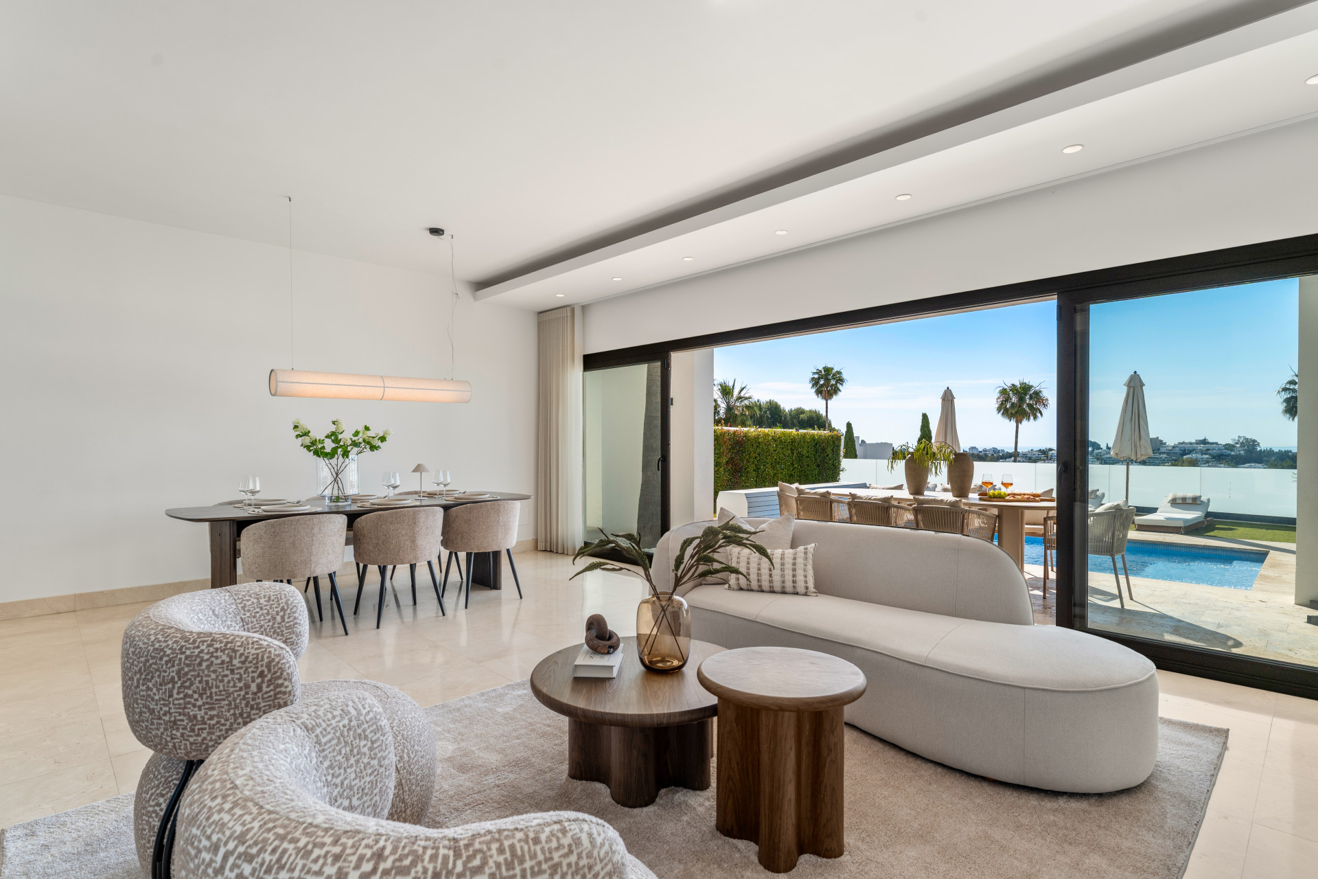 Modern living area with large glass doors opening to the pool.