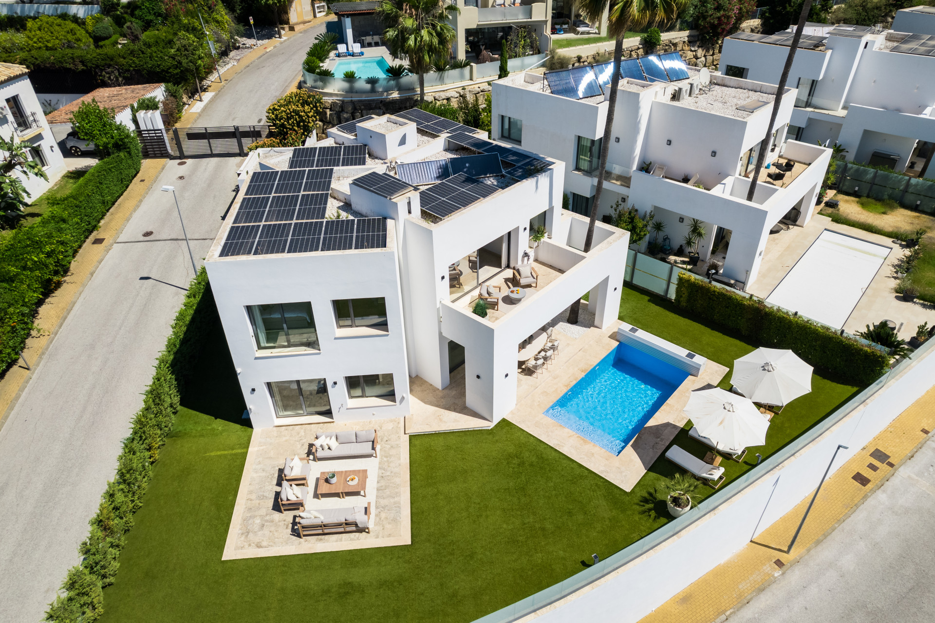 Aerial view of a villa in Benahavis with solar panels, pool, and landscaped lawn.