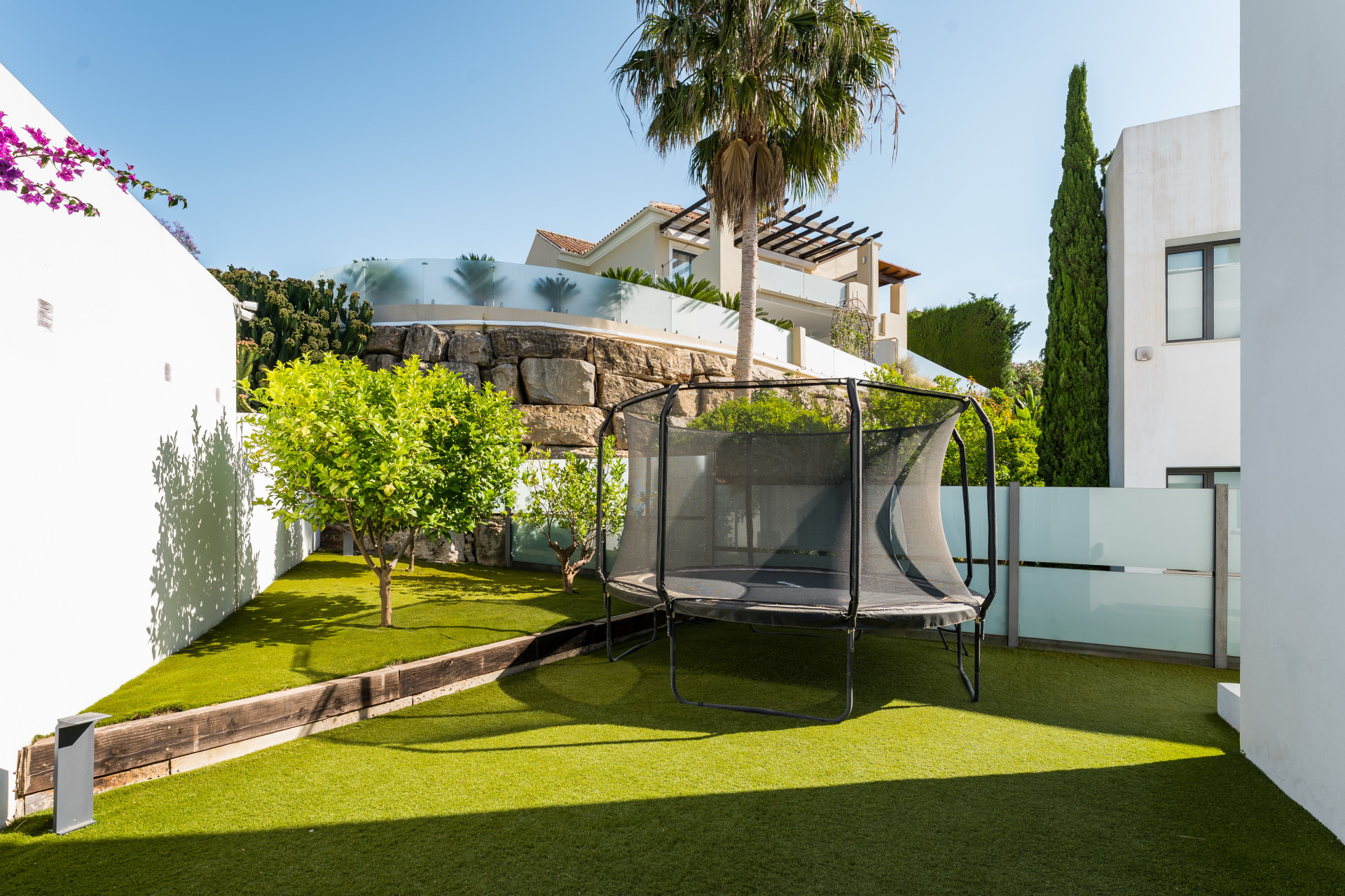 Backyard featuring a trampoline and landscaped garden