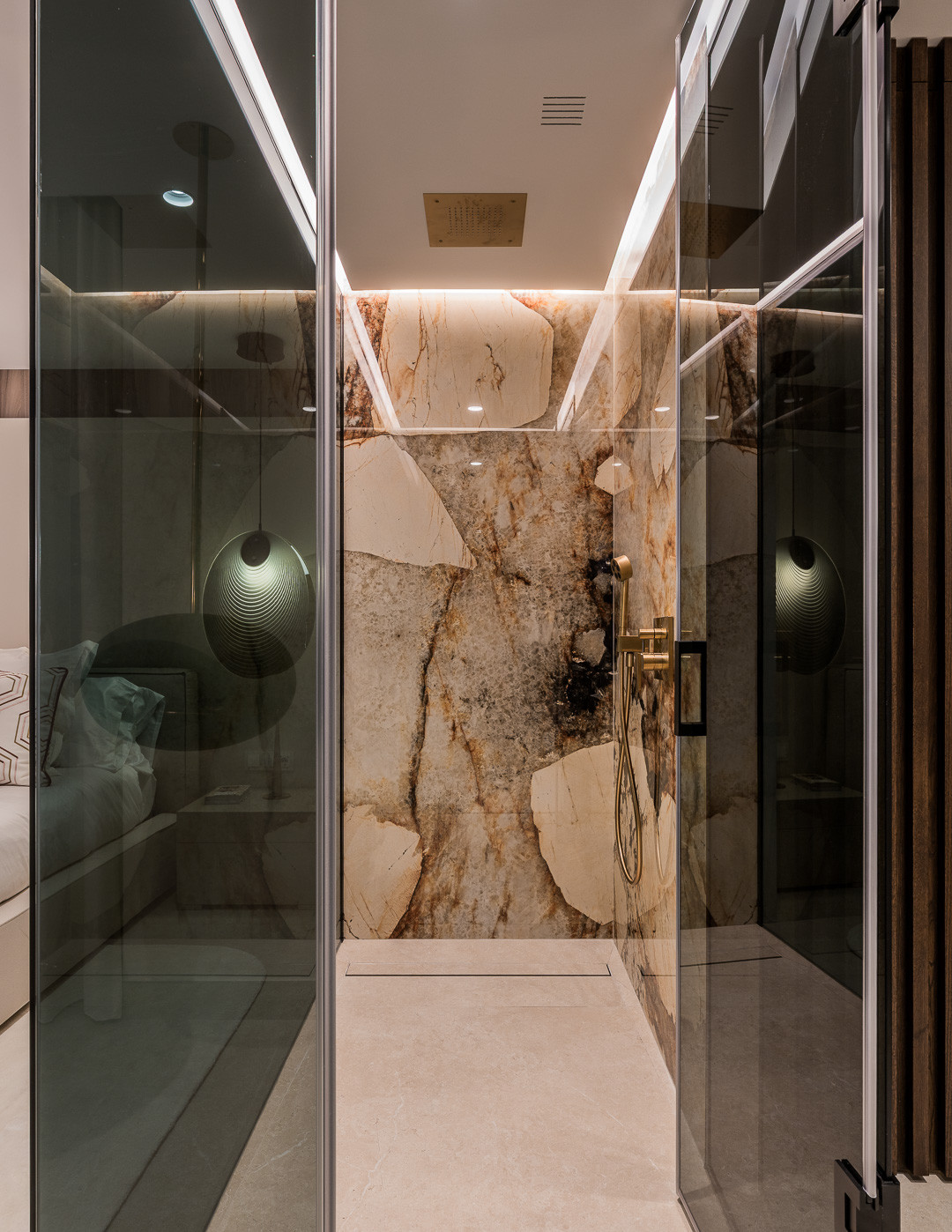 Walk-in glass shower with marble walls, a rainfall showerhead, and brass fixtures.