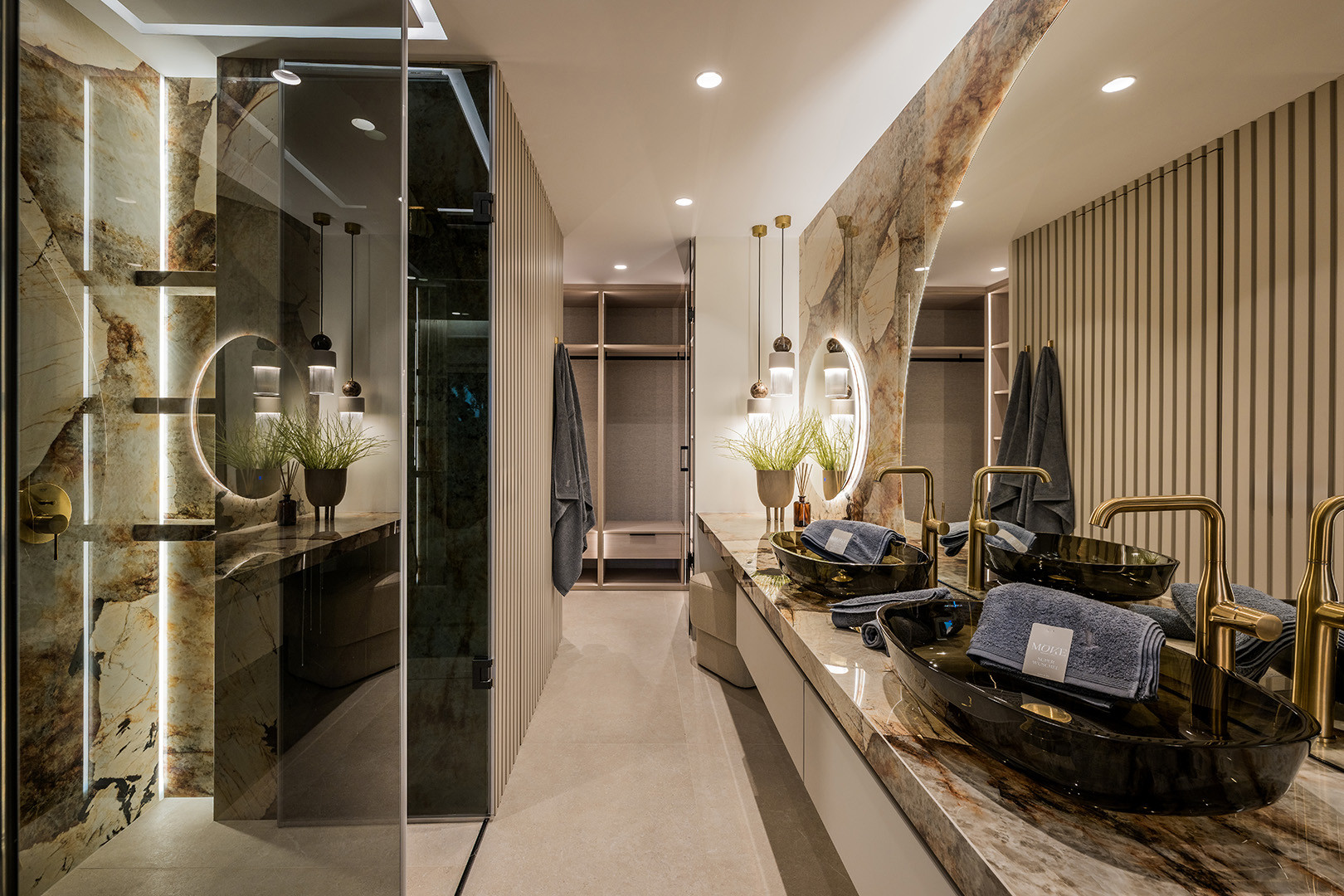Bathroom showing a marble vanity, walk-in shower with glass door, and an open closet space. Tiled floor.