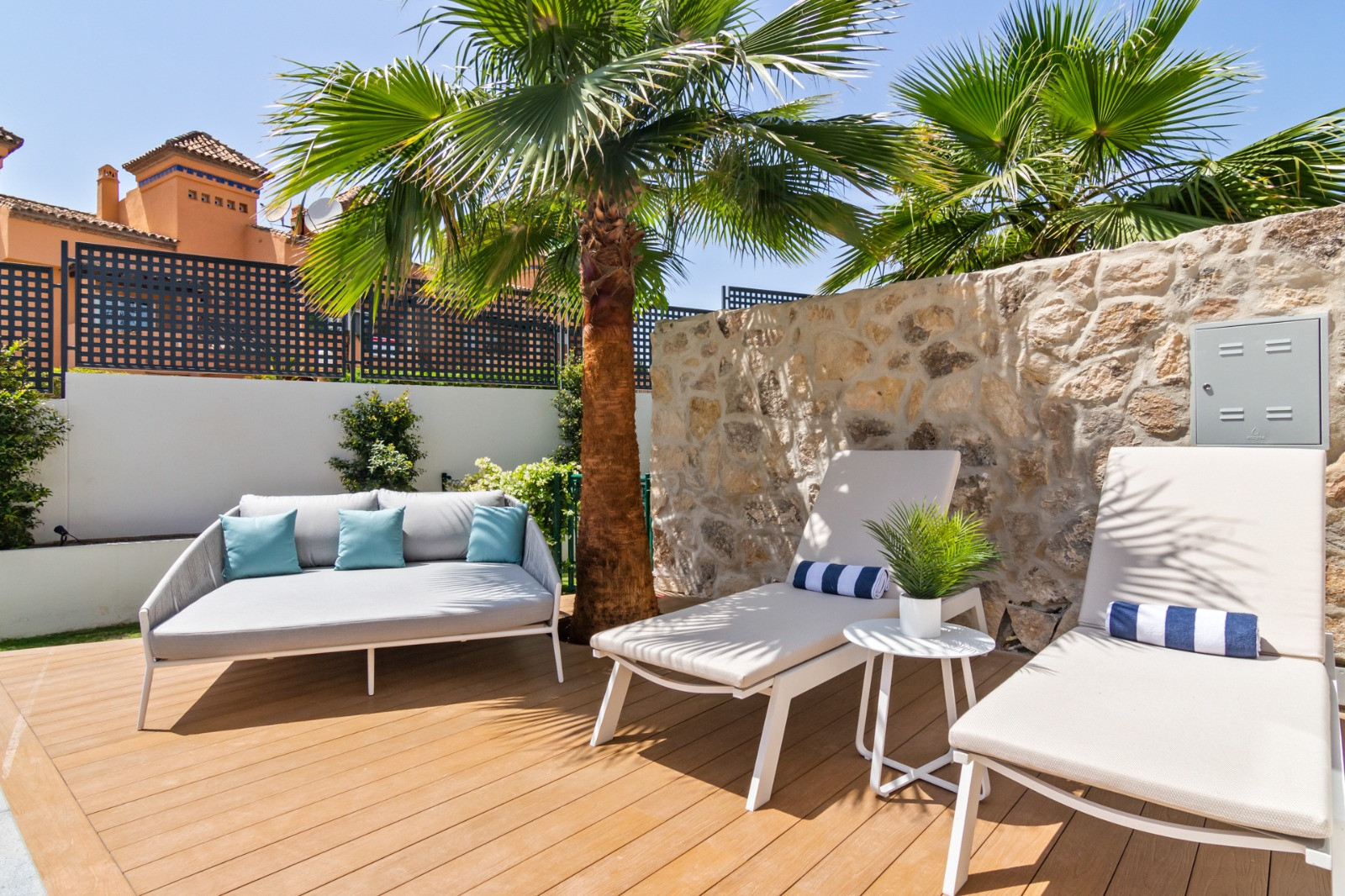 Close-up of outdoor seating with palm trees in the background.