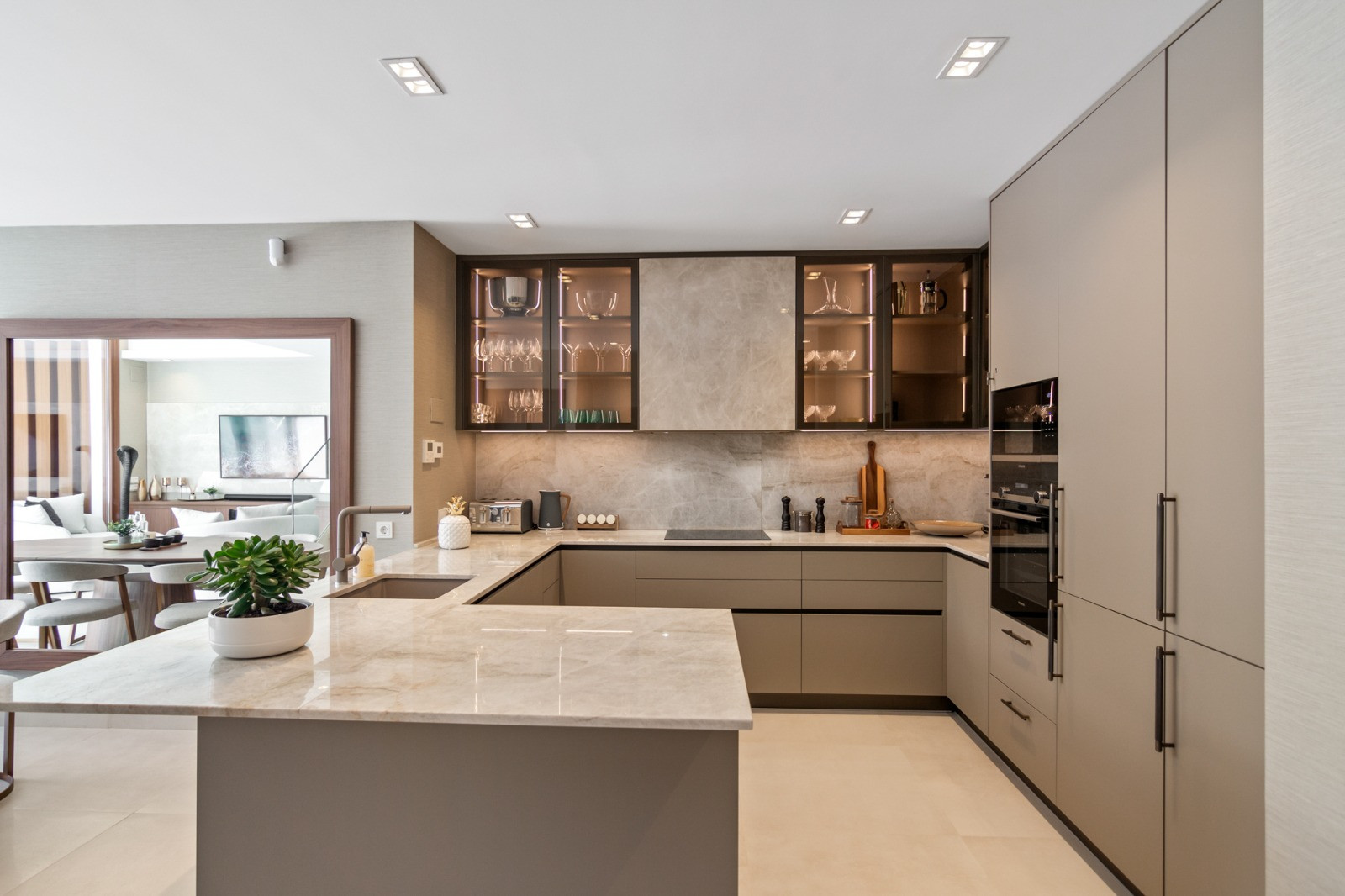 Kitchen featuring cabinets with glass doors and a countertop, highlighting an organized and stylish layout.