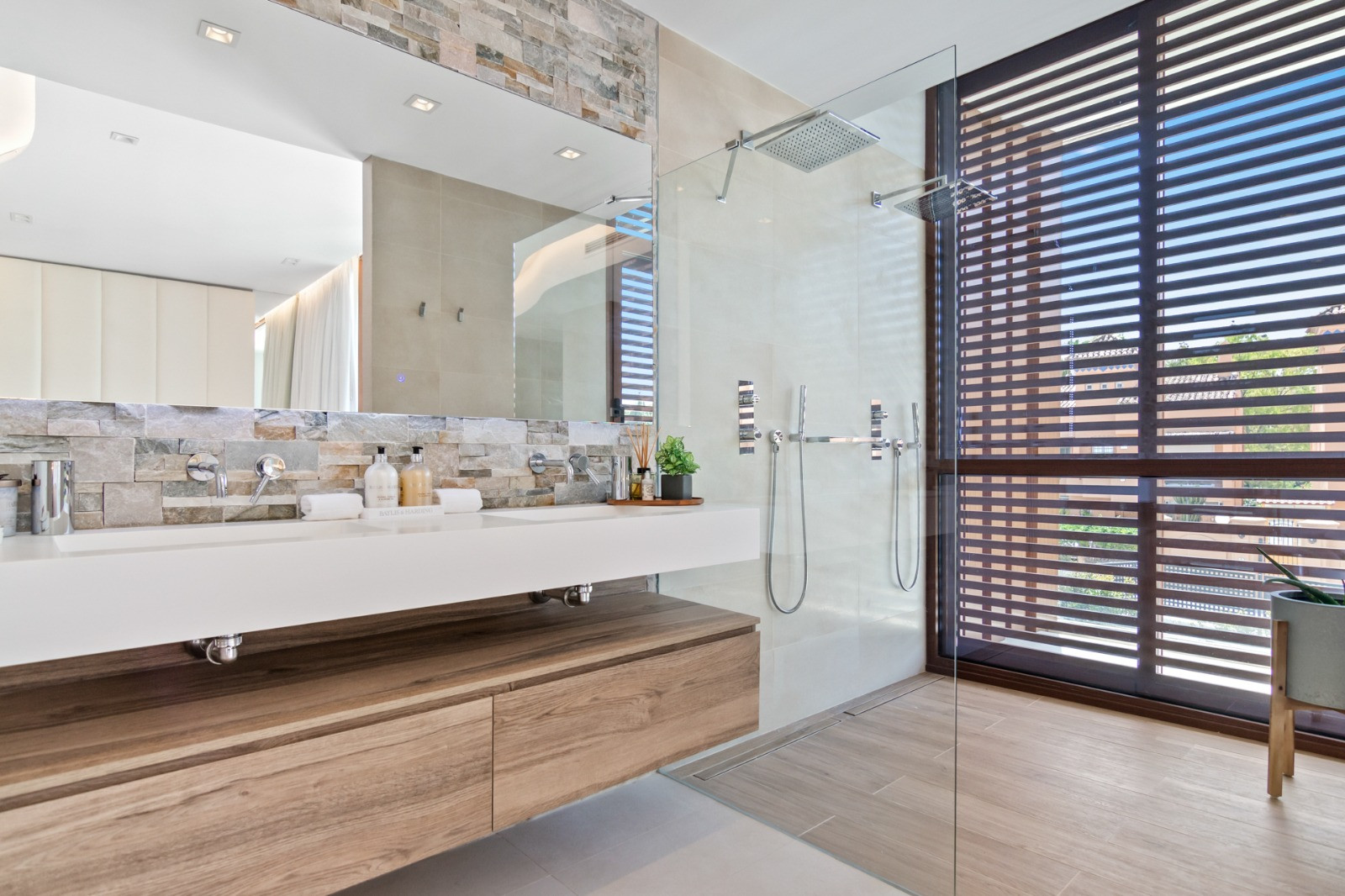 Modern bathroom with stone accents and dual rainfall showers.