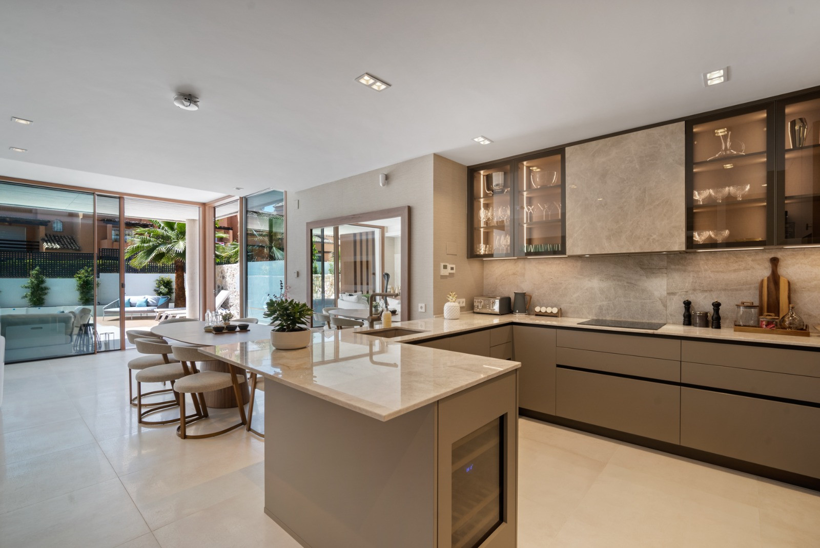 Kitchen with sleek cabinetry and a bar area, overlooking the outdoor space and equipped with modern appliances.
