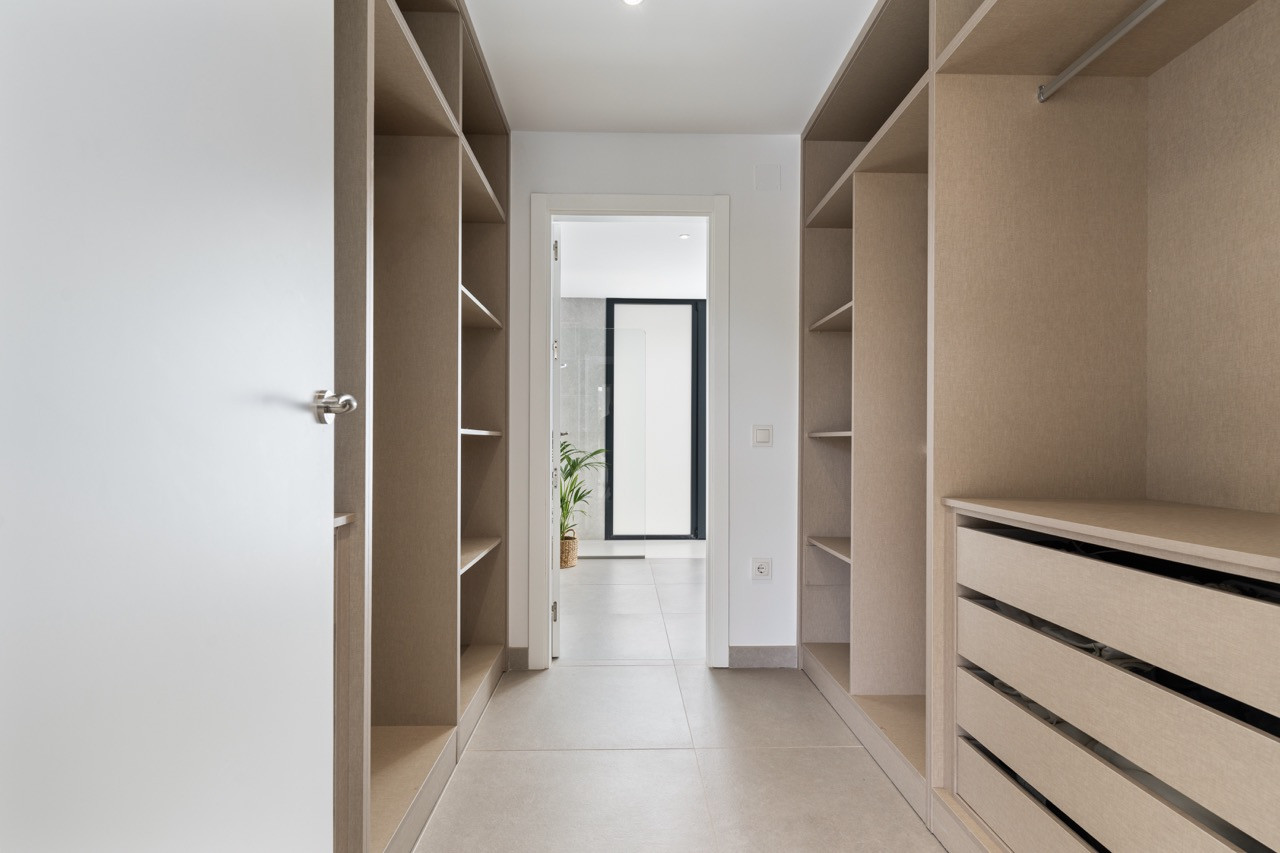 Empty hallway with built-in shelves and storage drawers on each side.