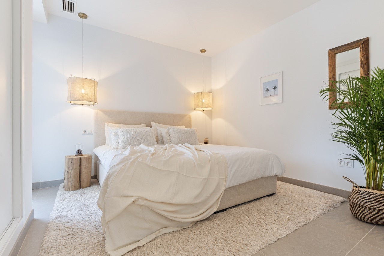 Cozy bedroom featuring a large bed with decorative pillows and soft lighting.
