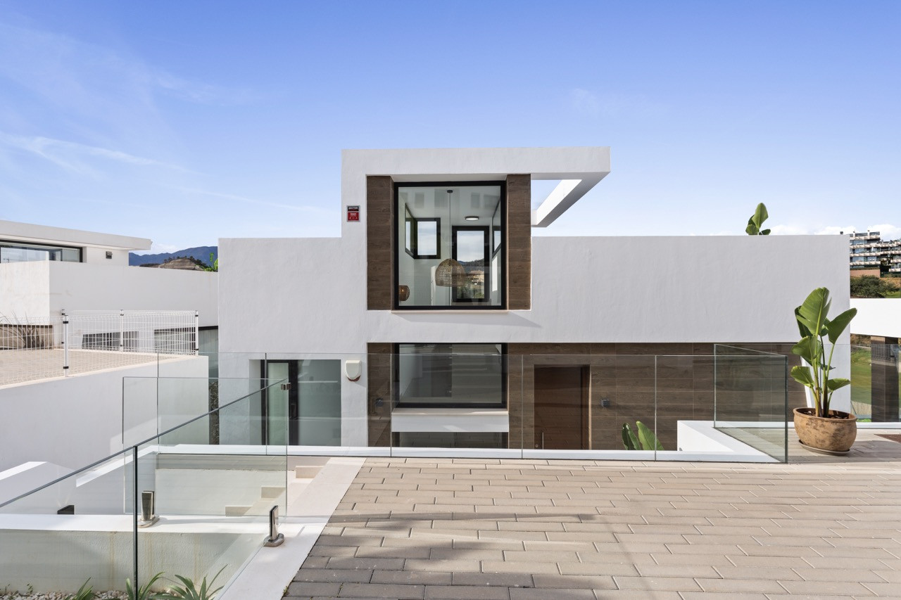 Exterior view of modern house with glass and wooden elements.
