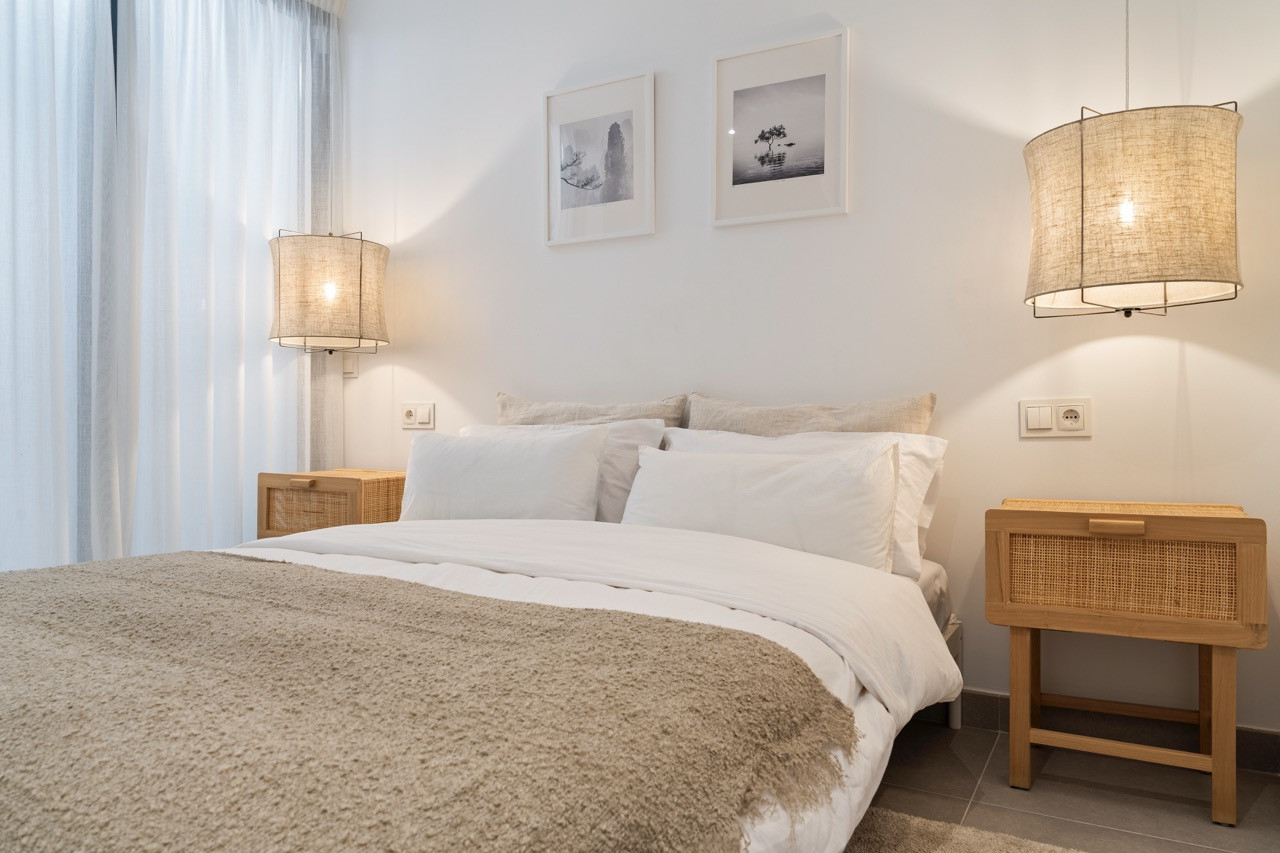 Inviting bedroom with sleek decor, bedside lamps, and wall art.