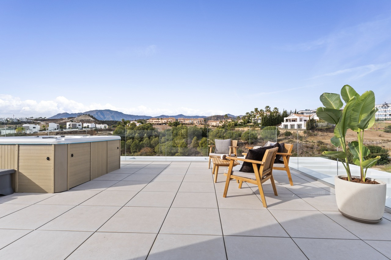 Outdoor seating area with plants and spa on the terrace.