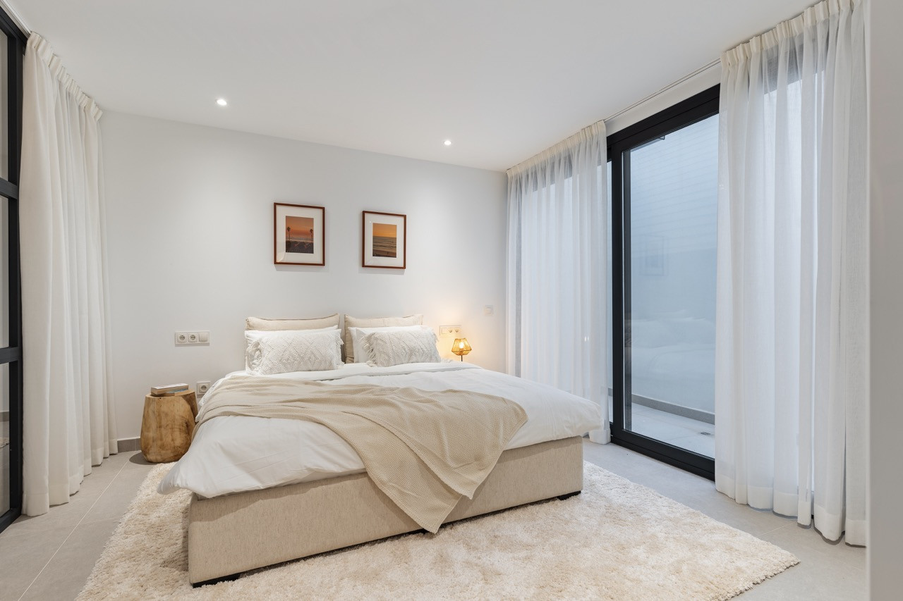 Cozy bedroom featuring a double bed and large glass doors to a terrace.