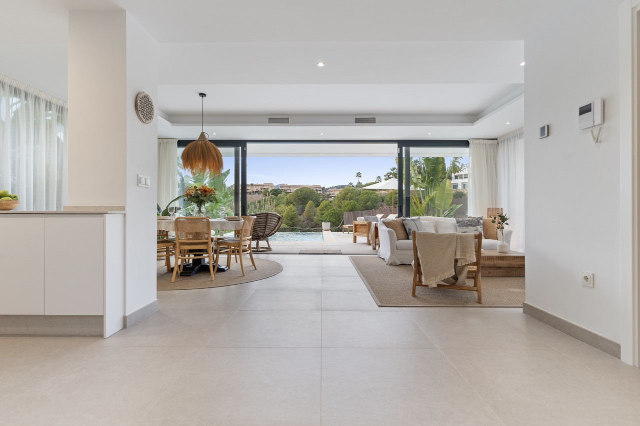 Interior space with dining area and living room framed by large glass doors.