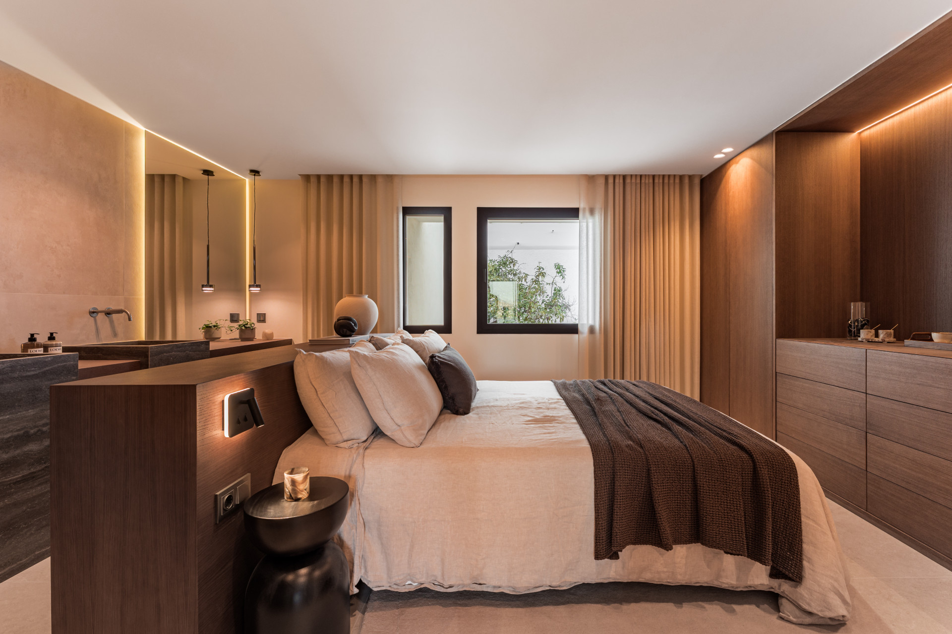 View of a bedroom featuring a bed, a wooden vanity with sink, and a built-in wooden dresser.