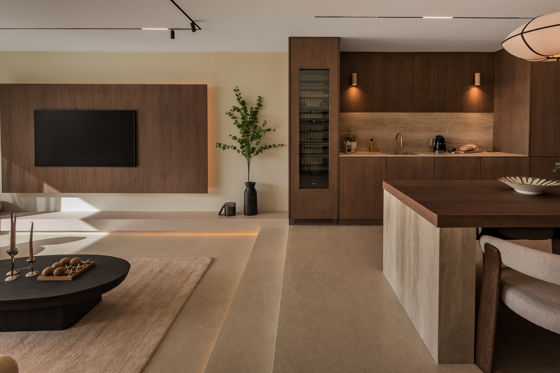 Open concept living area with kitchen, dining island, and a television wall panel.