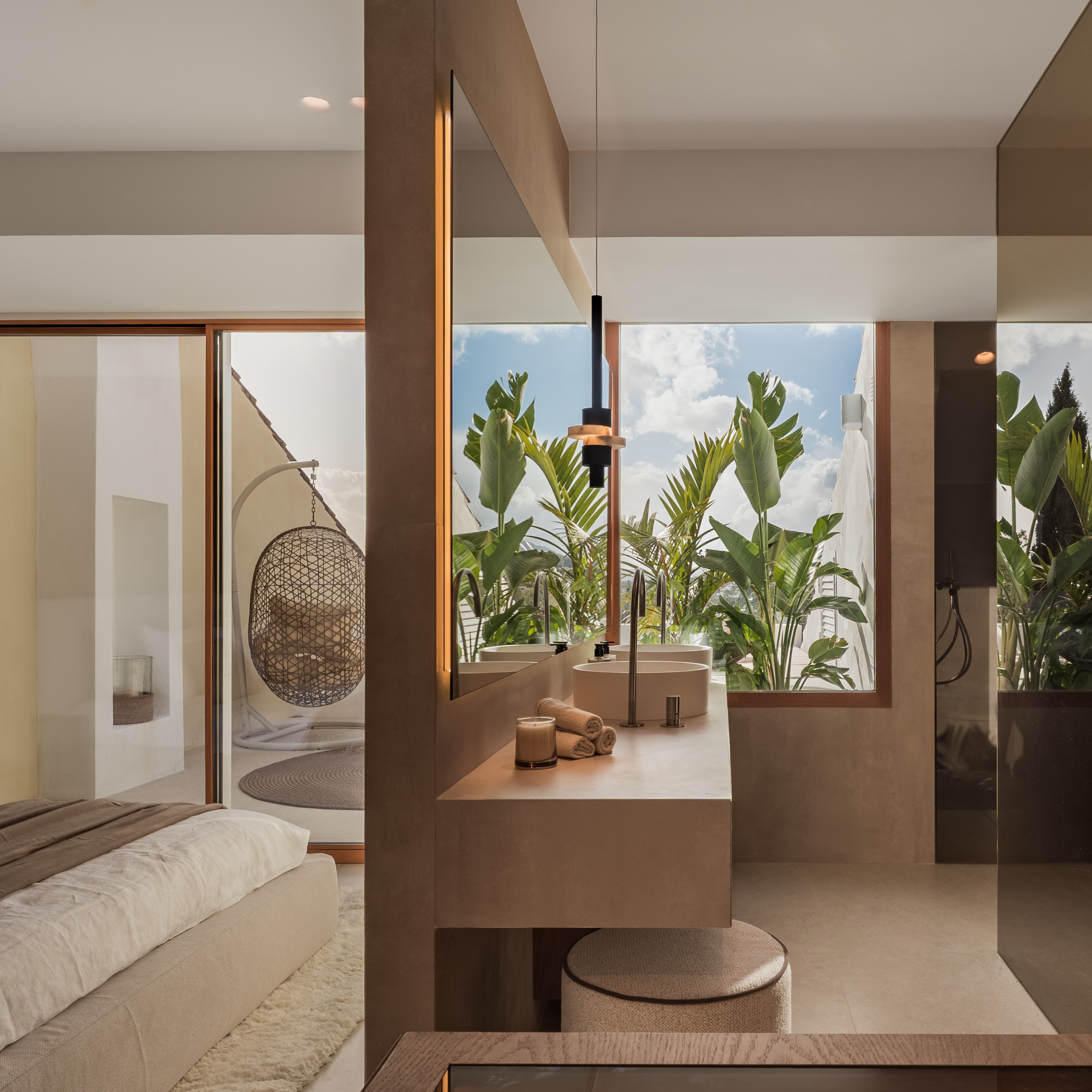 Bathroom vanity with dual sinks, large mirror, and a view of lush tropical foliage from the window.